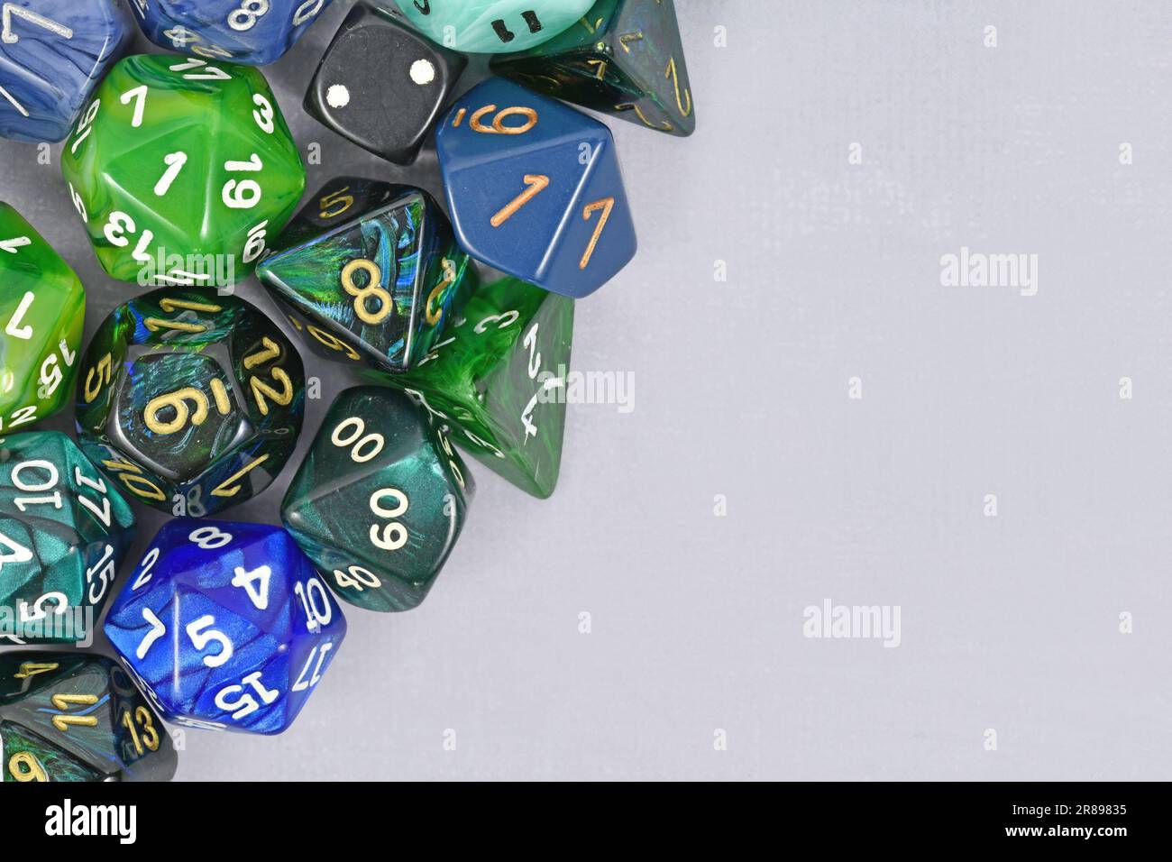 Blaue und grüne Rollen spielen Rollenwürfel auf grauem Hintergrund mit leerem Kopierbereich Stockfoto