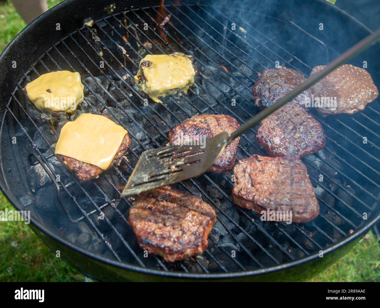 Nahaufnahme eines Grills bei einem Picknick mit Hamburgern und Cheeseburgern Stockfoto