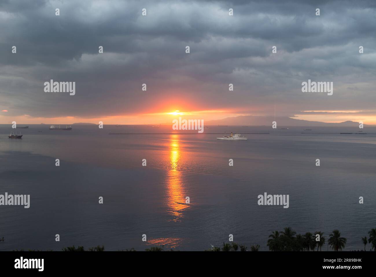 Schiffe in der Bucht von Manila bei Sonnenuntergang Stockfoto