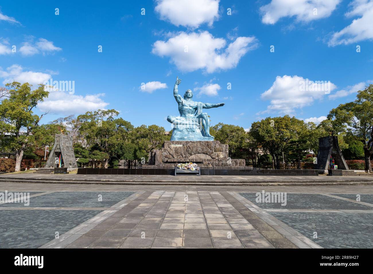 Die Friedensstatue im Friedenspark, Nagasaki, umgeben von üppigen Bäumen Stockfoto