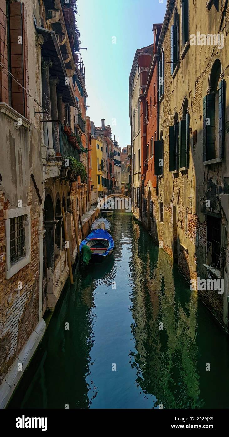 Ein traditionelles venezianisches Ruderboot, das zwischen den Gebäuden am Rand eines Kanals in Venedig, Italien, befestigt ist Stockfoto