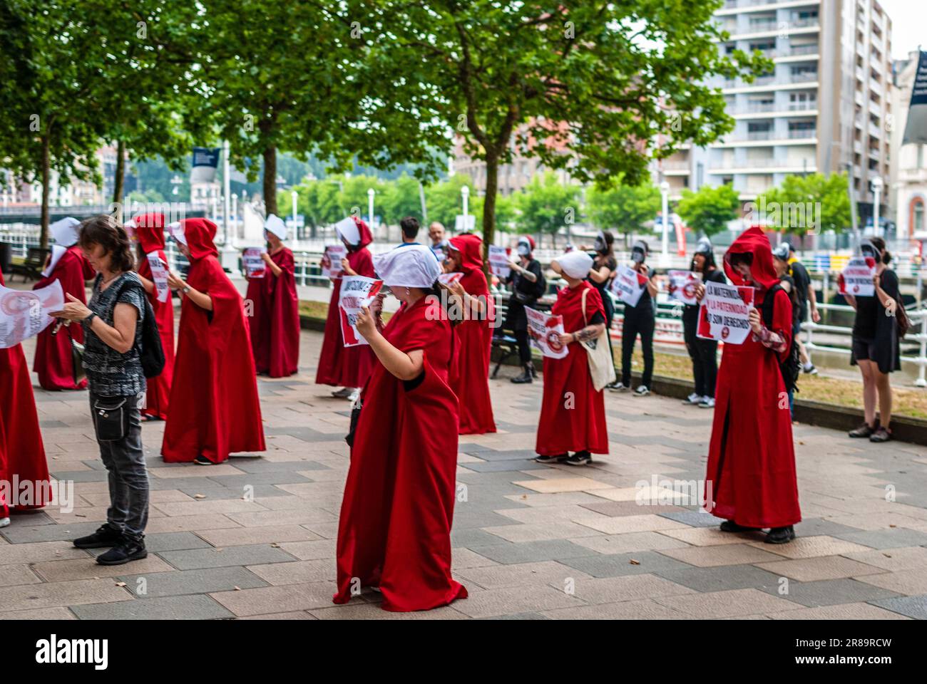 Radikale feministische Aktivisten, die in einem Kostüm aus der Serie „das Magazin“ gekleidet sind, nehmen an einer Demonstration gegen Leihmutterschaft Teil. Stockfoto