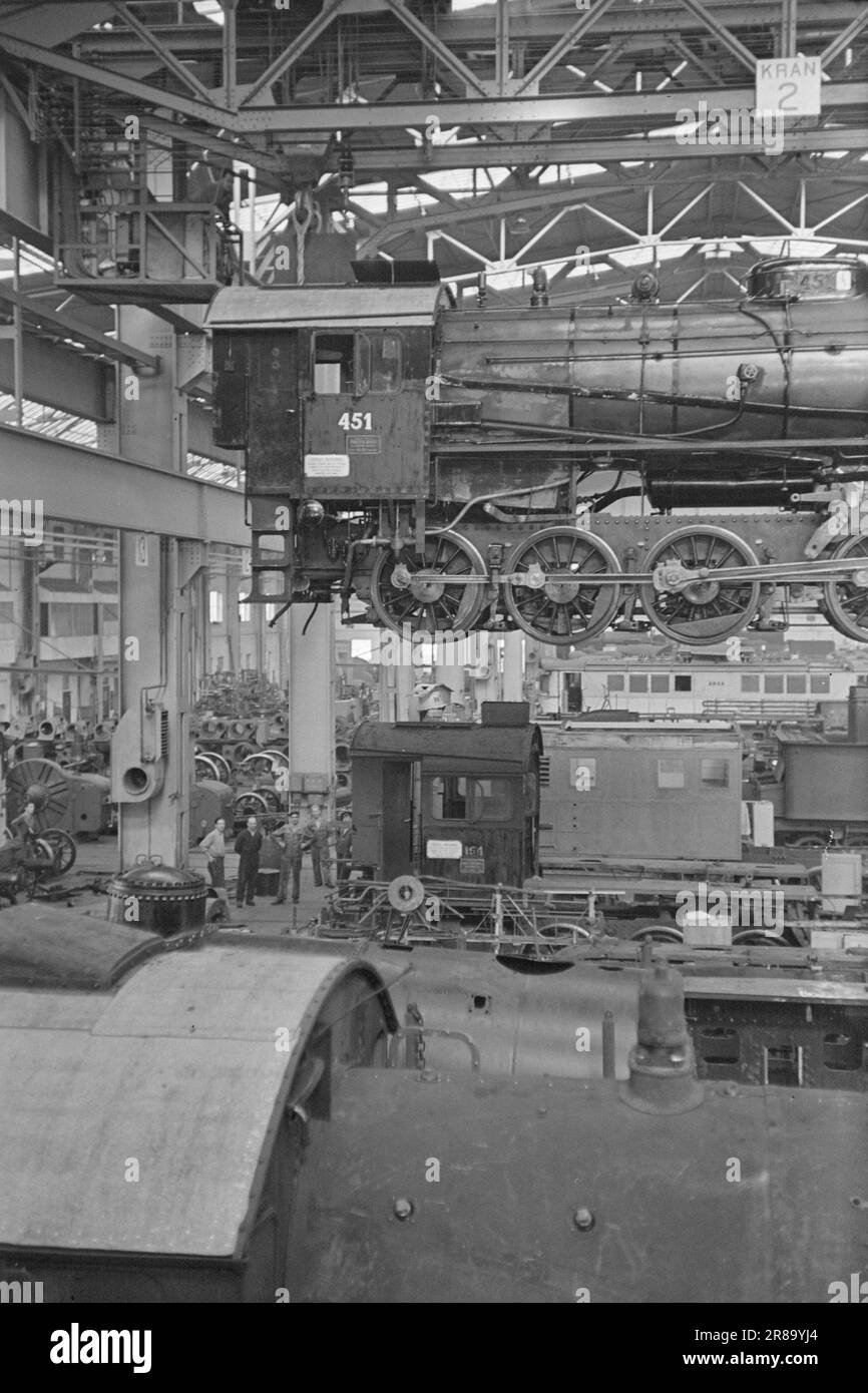 Derzeit 21-3-1947: Grorud Railway WorkshopDie toten Zugtiere, die fünf Jahre lang besetzt waren, forderten einen hohen Tribut bei allen Arten von Eisenbahnausrüstung. Die Deutschen haben nicht gerade Lokomotiven und Wagen ausgetauscht und Ersatzteile waren extrem schwer zu beschaffen. Es ist das Problem der Traktionsleistung, das die Eisenbahn vor allem daran gehindert hat, die Bahnreisenden in der gewünschten Weise zu bedienen. Sobald die Lokomotive in die Werkstatt gelangt ist, wird sie unter dem Dach angehoben, die einzelnen Teile werden auseinandergenommen und an verschiedene Reparaturabteilungen geschickt. In der befinden sich normalerweise 20 Lokomotiven Stockfoto