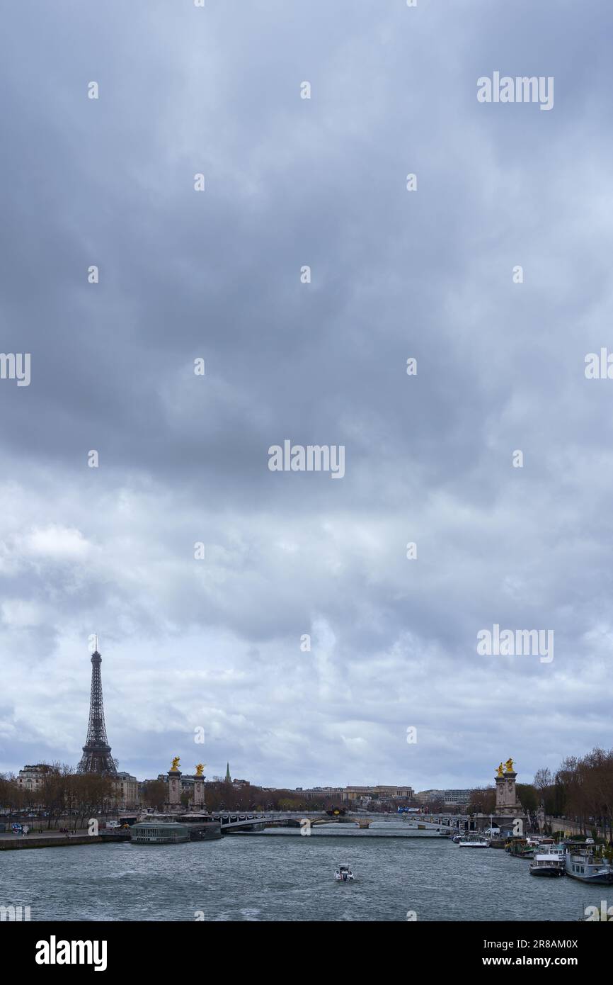 Bewölkter Tag im Frühling mit Blick auf die seine, die Brücke Pont Alexandre III und den Eiffelturm. Paris, Frankreich. 25. März 2023. Stockfoto