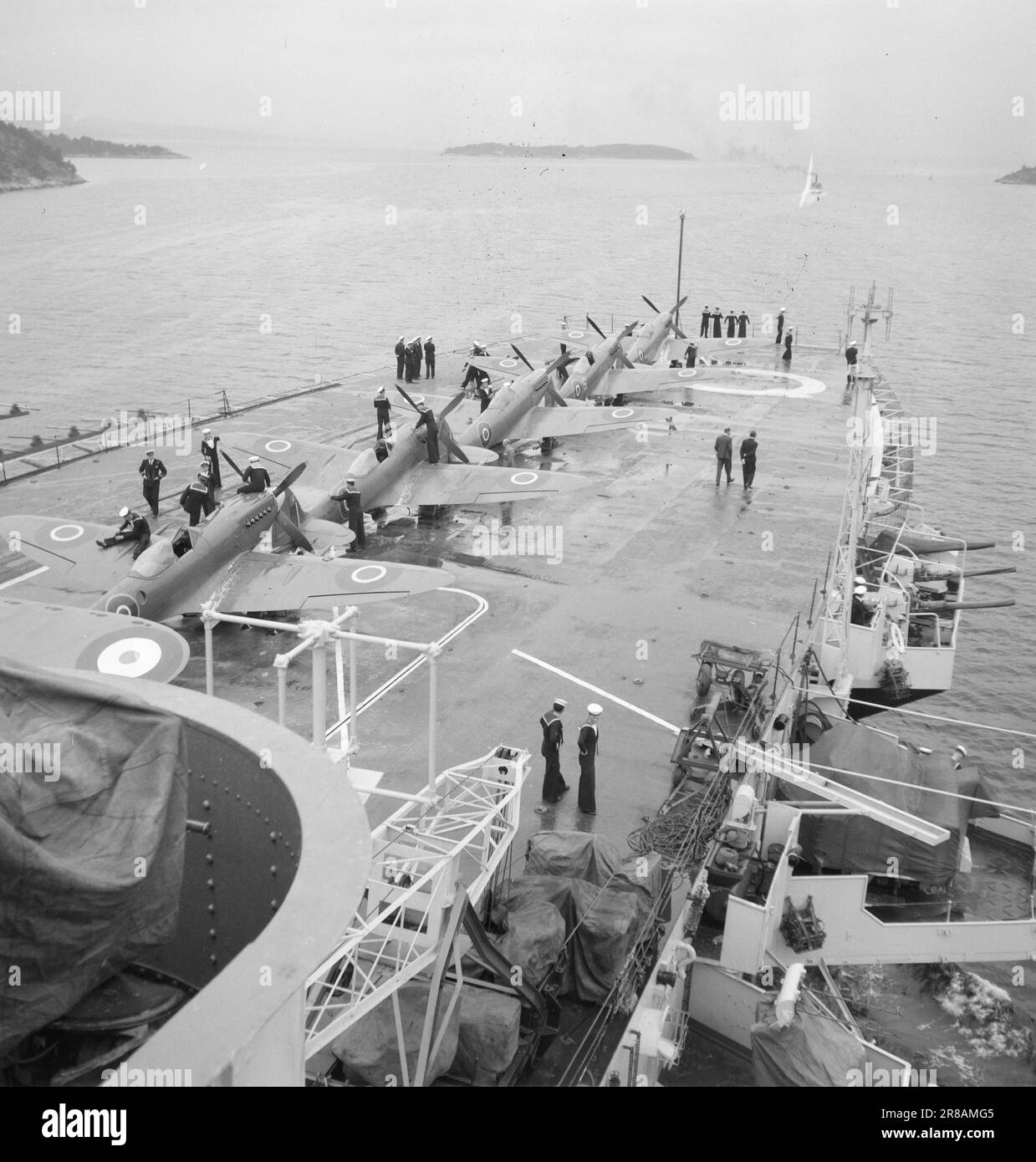 Derzeit 12-3-1947: Englische Fåtebösek Einheiten der britischen Heimatflotte besuchen Anfang Juni norwegische Küstenstädte. An Bord von "Vengeance" war der Oberbefehlshaber der britischen Marine, erster Seelord, Admiral Cunningham. Dieser erste offizielle britische Flottenbesuch nach dem Krieg fand auf norwegische Initiative statt, als Salut und dank der britischen Marine. Der majestätische Koloss „Rache“ auf dem Weg zum Oslofjord. Die Crew ist dabei, die Flugzeuge auf dem Startdeck zu polieren und das Boot für die Ankunft in Oslo gut aussehen zu lassen. An den meisten Orten wird die Öffentlichkeit Zugang zum W haben Stockfoto