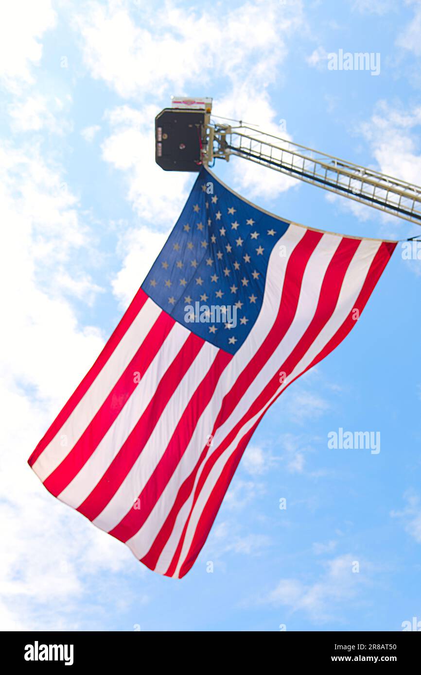 Pater's Day Auto Show - Hyannis, Massachusetts, Cape Cod - USA. Die amerikanische Flagge fliegt von einer Leiter des Feuerwehrturms von Hyannis Stockfoto