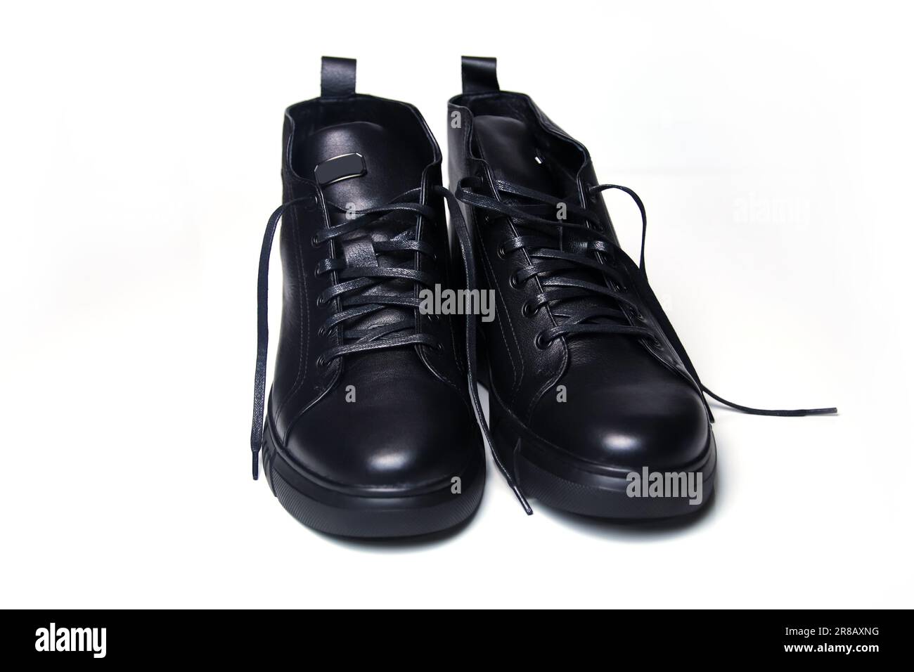 Schwarze Lederschuhe für Herren auf einem sauberen weißen Hintergrund. Diese stylischen Stiefel sind aus hochwertigem Leder gefertigt. Der geschlossene Schuss zeigt Stockfoto