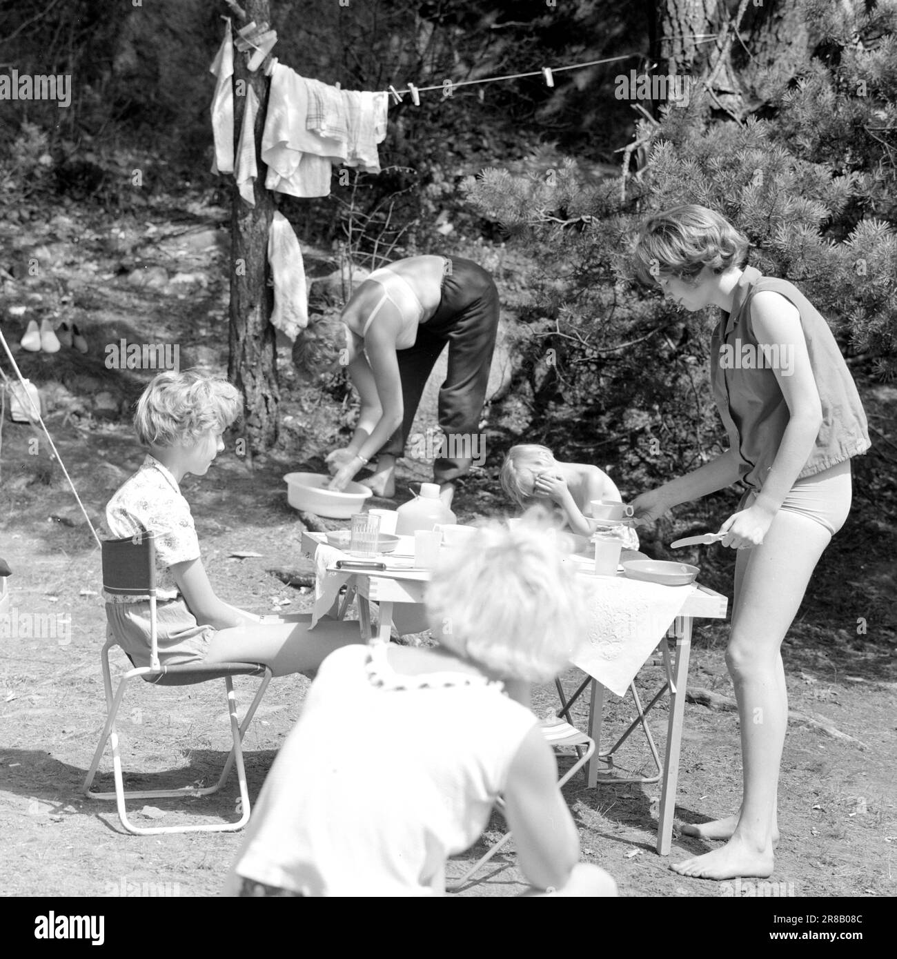 Derzeit 31-6-1960: Der Feiertag steht vor Tausenden von Menschen, die mit dem Auto oder Zelt in Urlaub fahren. Ein neuer Tag, an dem die ganze "Gang" versammelt ist. Das Frühstück ist praktisch fertig, und der Duft von Speck und Eiern – ein notwendiges Element bei jedem Frühstück im Grünen – hängt günstig über den Zelten. Foto: Aage Storløkken / Aktuell / NTB ***FOTO NICHT VERARBEITET*** Stockfoto