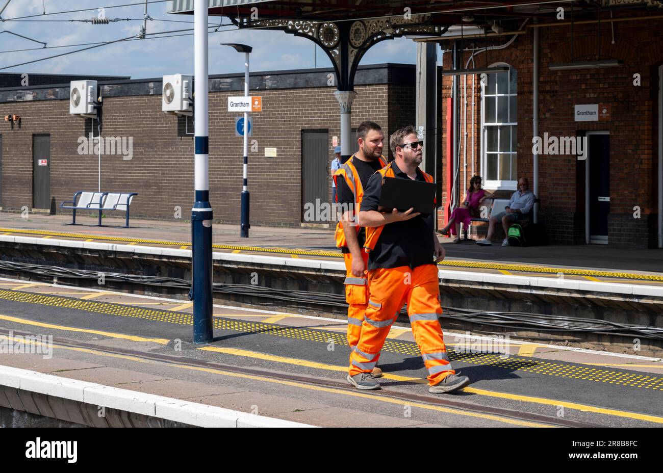 Bahnhof Grantham – Eisenbahningenieure oder Wartungspersonal, die einen Bahnsteig entlang laufen Stockfoto