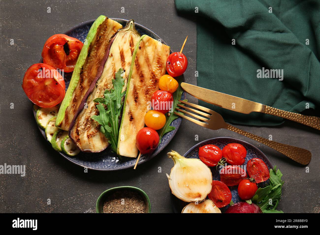 Teller mit leckerem gegrilltem Gemüse auf dunklem Hintergrund Stockfoto