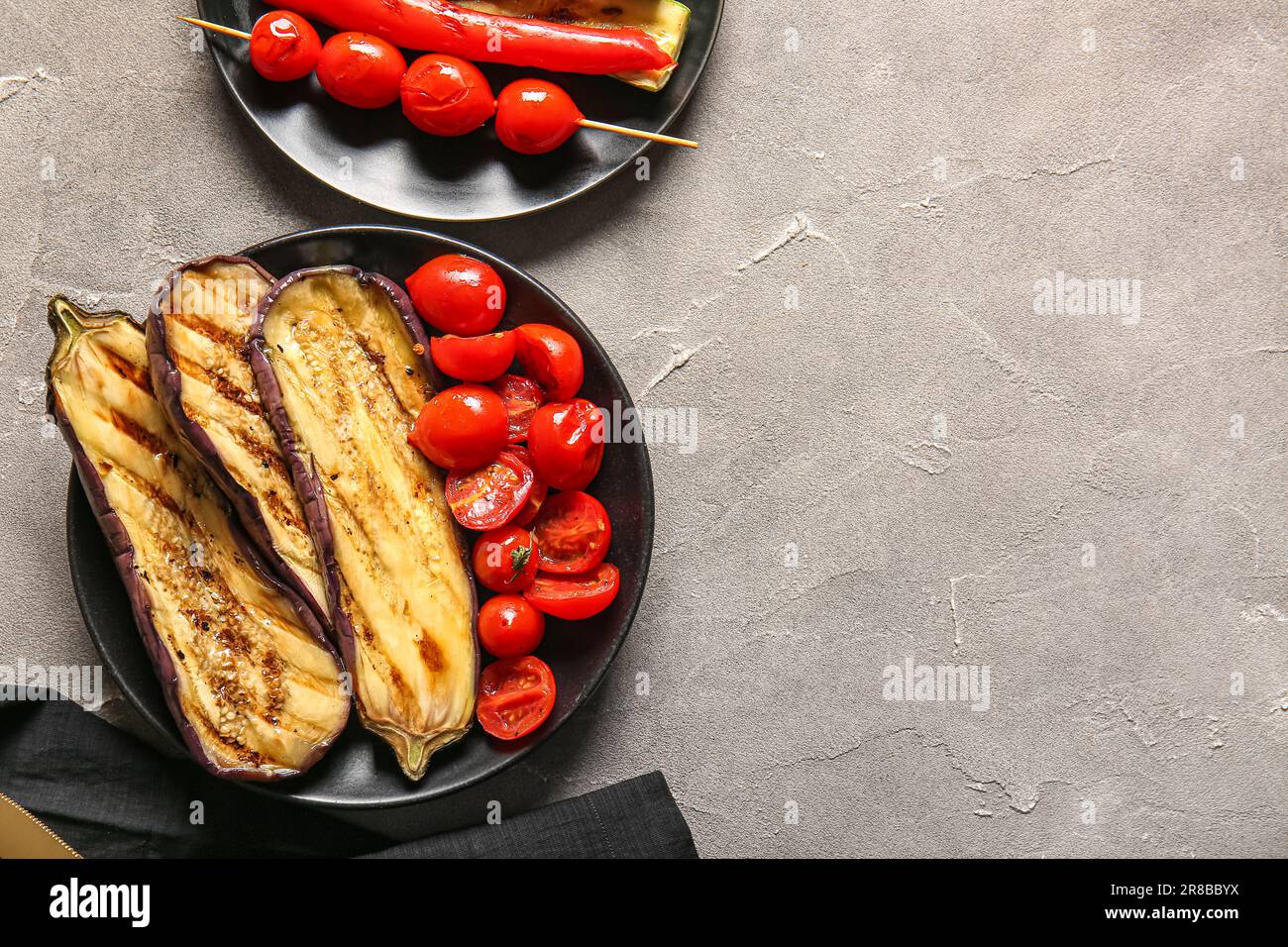 Teller mit leckerem gegrilltem Gemüse auf grauem Hintergrund Stockfoto