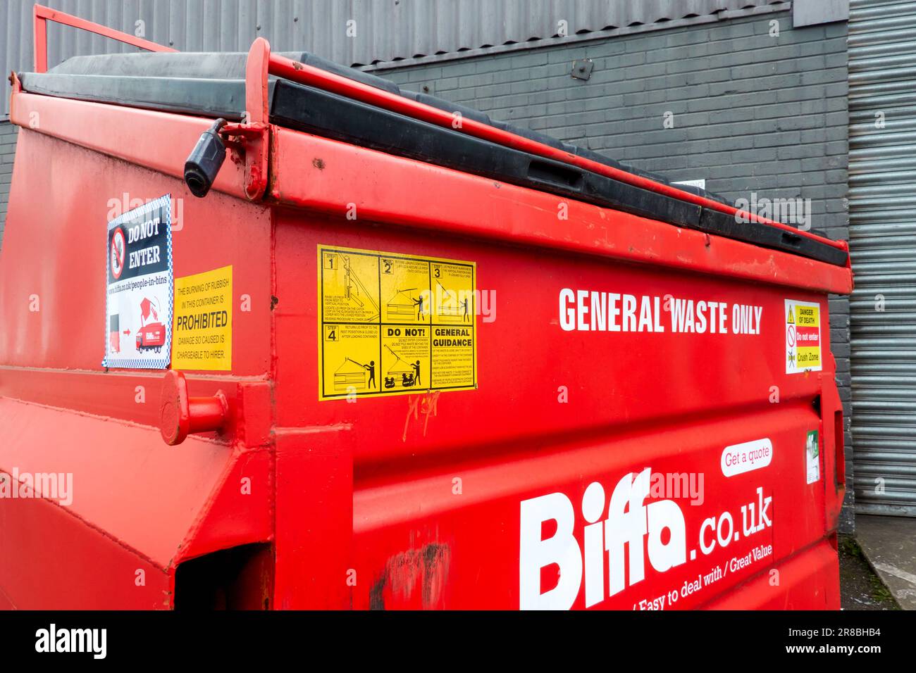 Warnaufkleber auf einem roten metallrecyclingplatz Stockfoto