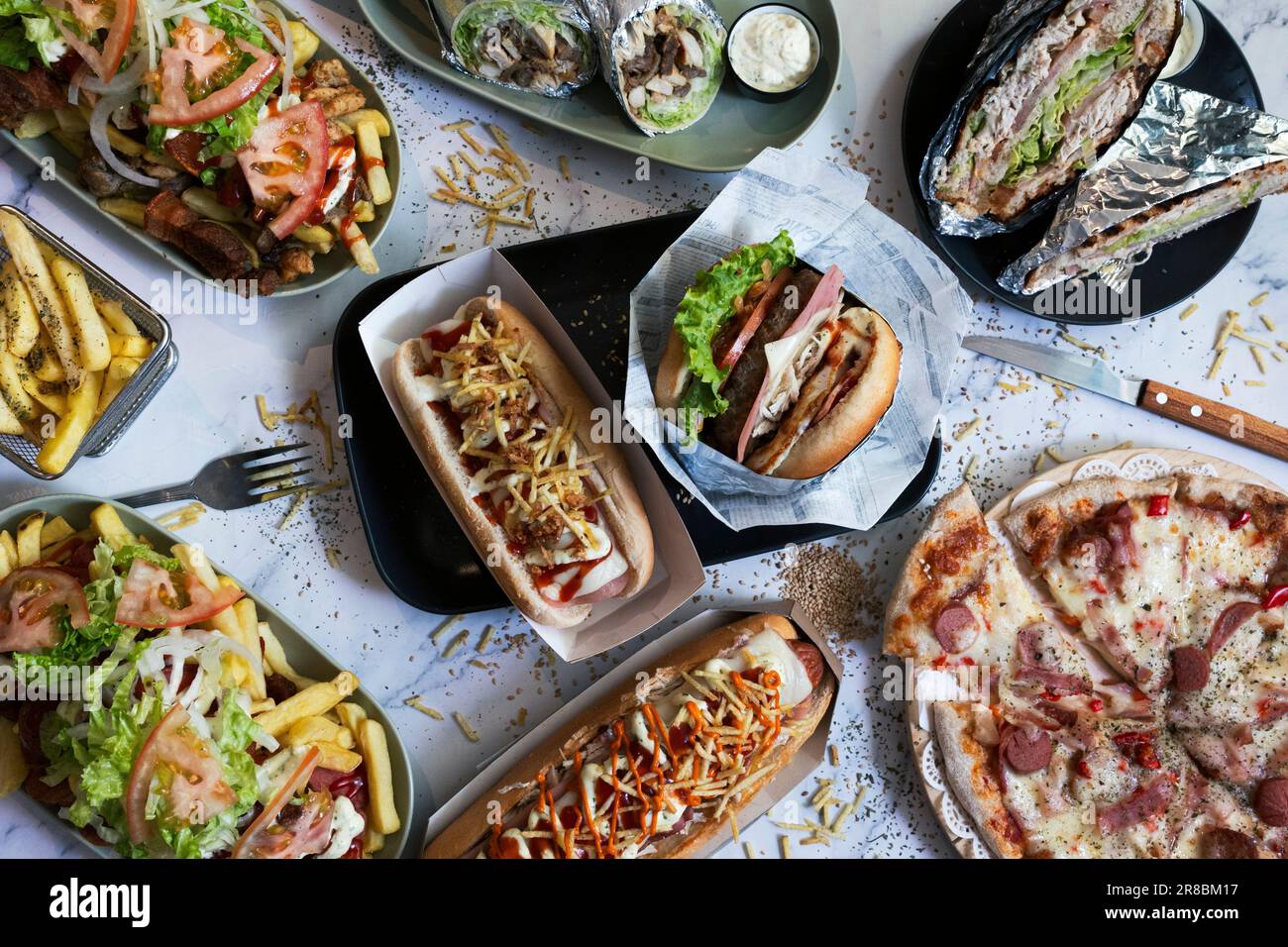 Auswahl an Junk-Food-Gerichten auf dem Tisch. Hot Dogs, Pommes Frites, Salchipapas Stockfoto