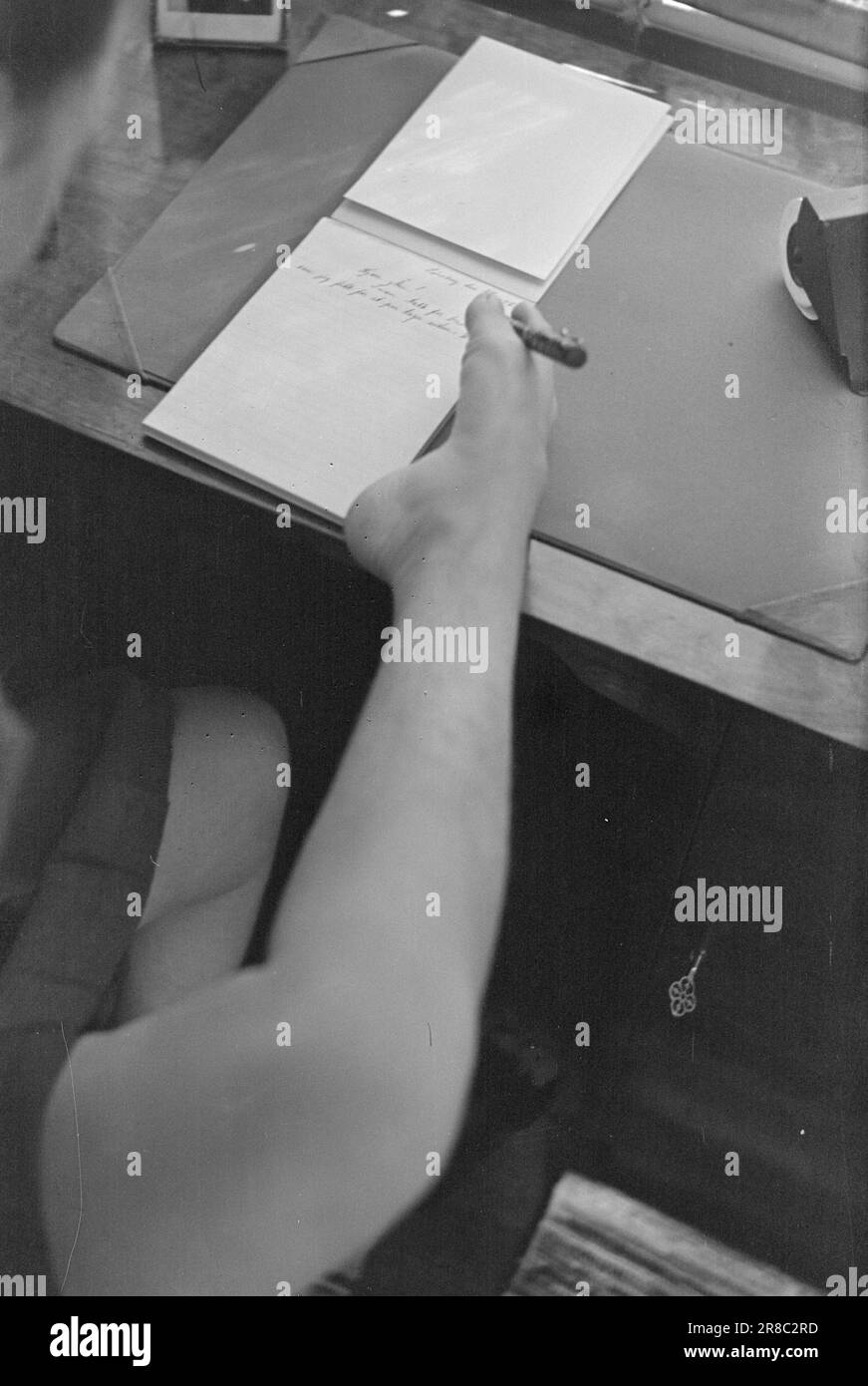 Tatsächlich 20-4-1947: Armlos Tønsberg Armlos Tønsberg Mädchen, das auf eigenen Füßen steht Mary Bratvold hat keine Arme, aber hält sich selbst als Telefonzentrale aufrecht. Sie bedient die Telefonzentrale mit ihren Füßen. Maria schreibt einem Freund einen Brief und hält den Stift natürlich mit ihren Zehen. Sie hat eine ungewöhnlich gute „Handschrift“ und schreibt auch ziemlich schnell. Foto: Th. Skotaam/Aktuell/NTB ***FOTO NICHT VERARBEITET*** Stockfoto