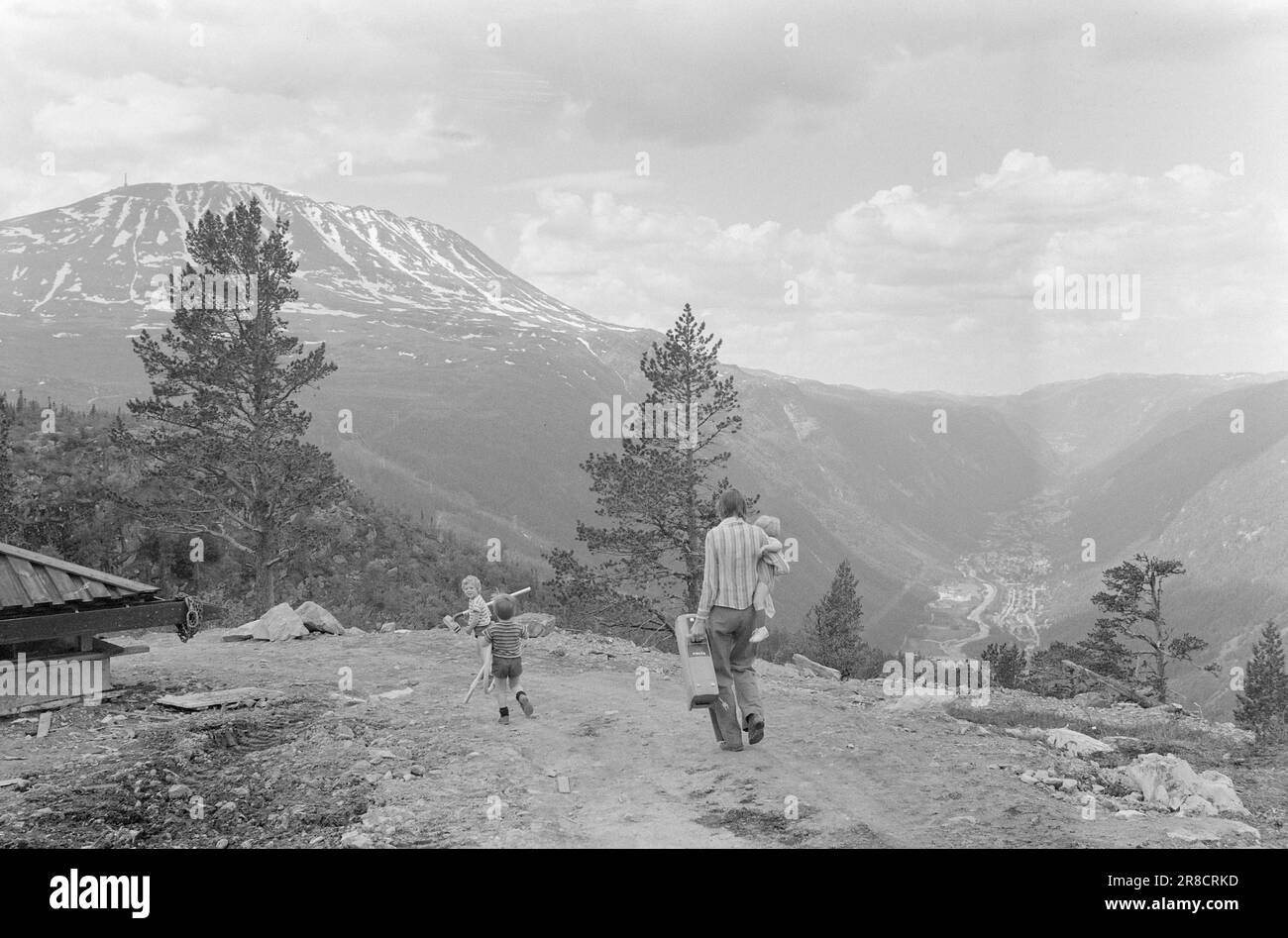 Aktuell 28 - 3 - 1974: Hüttenurlaub in einer neuen WegEven in Norwegen haben wir keinen Platz für eine unbegrenzte Anzahl von Hütten und Ferienhäusern in unserer geräumigen Natur, wenn es wieder unberührte Gebiete geben soll. Wir müssen mehr Leute für jede Hütte zusammenbringen und sie in Dörfern mit guter Abfallentsorgung und Abwasser abholen, wie es in Gausta Fjellgrend geschehen ist. In Gausta Fjellgrende besitzen 48 Genossenschaftsbesitzer acht komfortable und attraktive Hütten. Gaustatoppen mit 1883 Metern über dem Meeresspiegel und NATO-Verbindung, einem unsichtbaren NATO-Aufzug im Inneren des Berges und Rjukan 250 Meter über dem Meeresspiegel Stockfoto