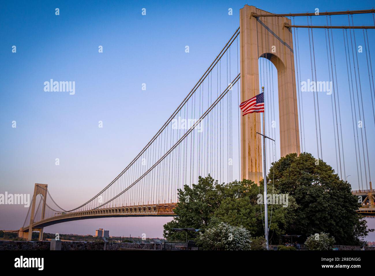 Verrazano Narrows Bridge bei Sonnenuntergang mit amerikanischer Flagge Stockfoto