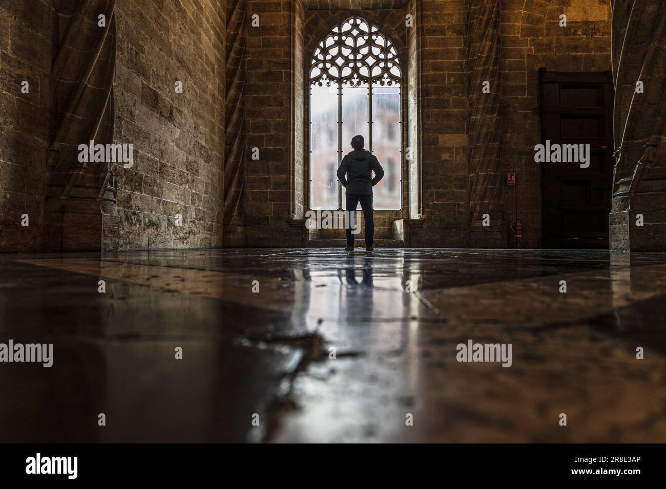 Spanien, Valencia, Rückansicht eines Mannes, der durch ein Fenster in einer alten, leeren Kirche schaut Stockfoto