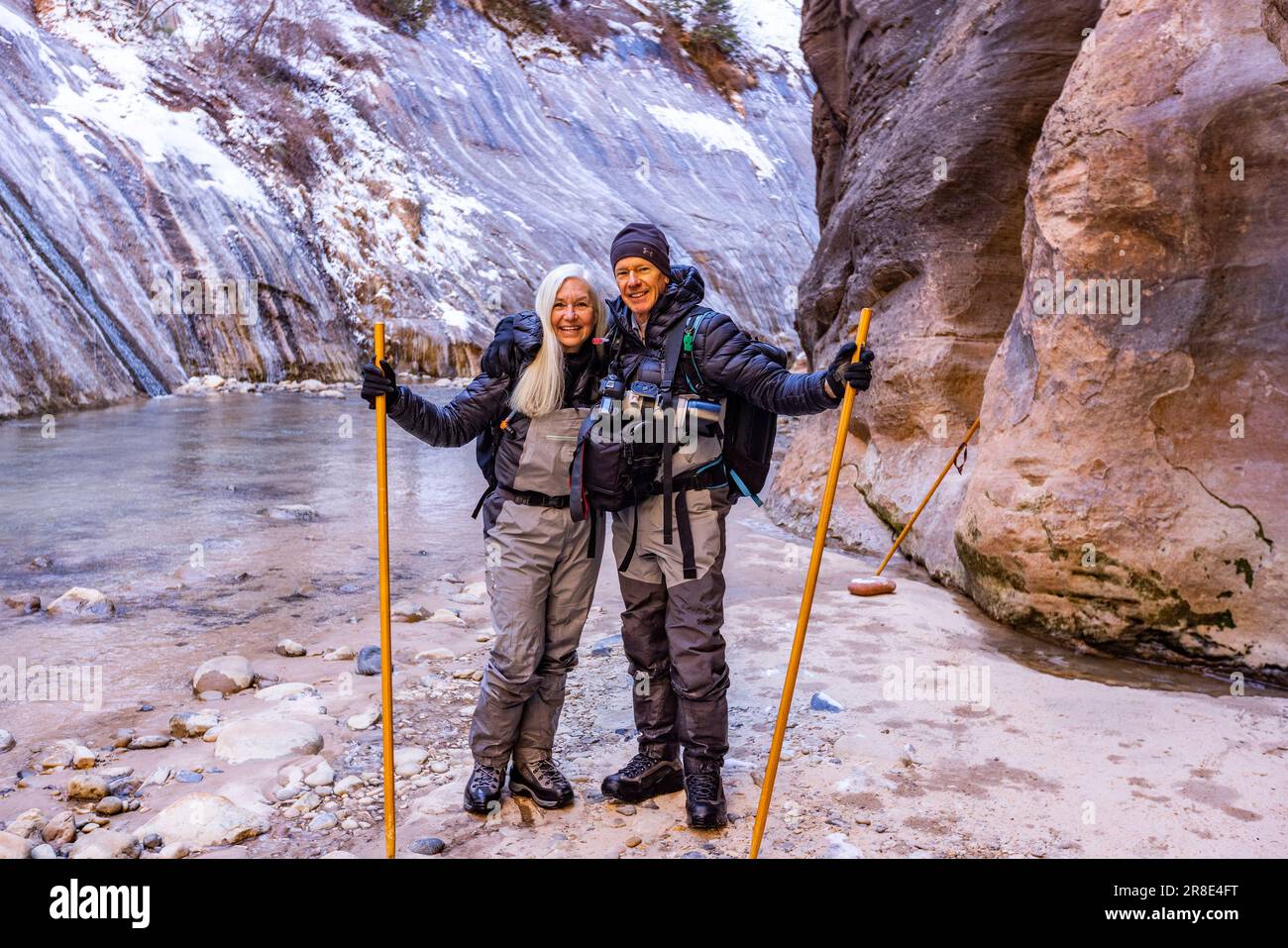 USA, Utah, Springdale, Zion National Park, Seniorenpaar überquert den Fluss während einer Wanderung in den Bergen Stockfoto