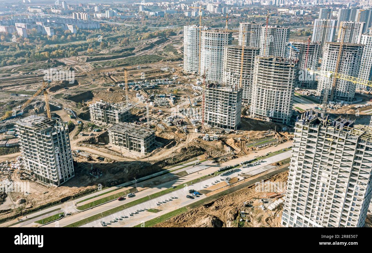 Große Baustelle mit Kränen, Baumaschinen und Wohngebäuden im Bau. Draufsicht. Stockfoto