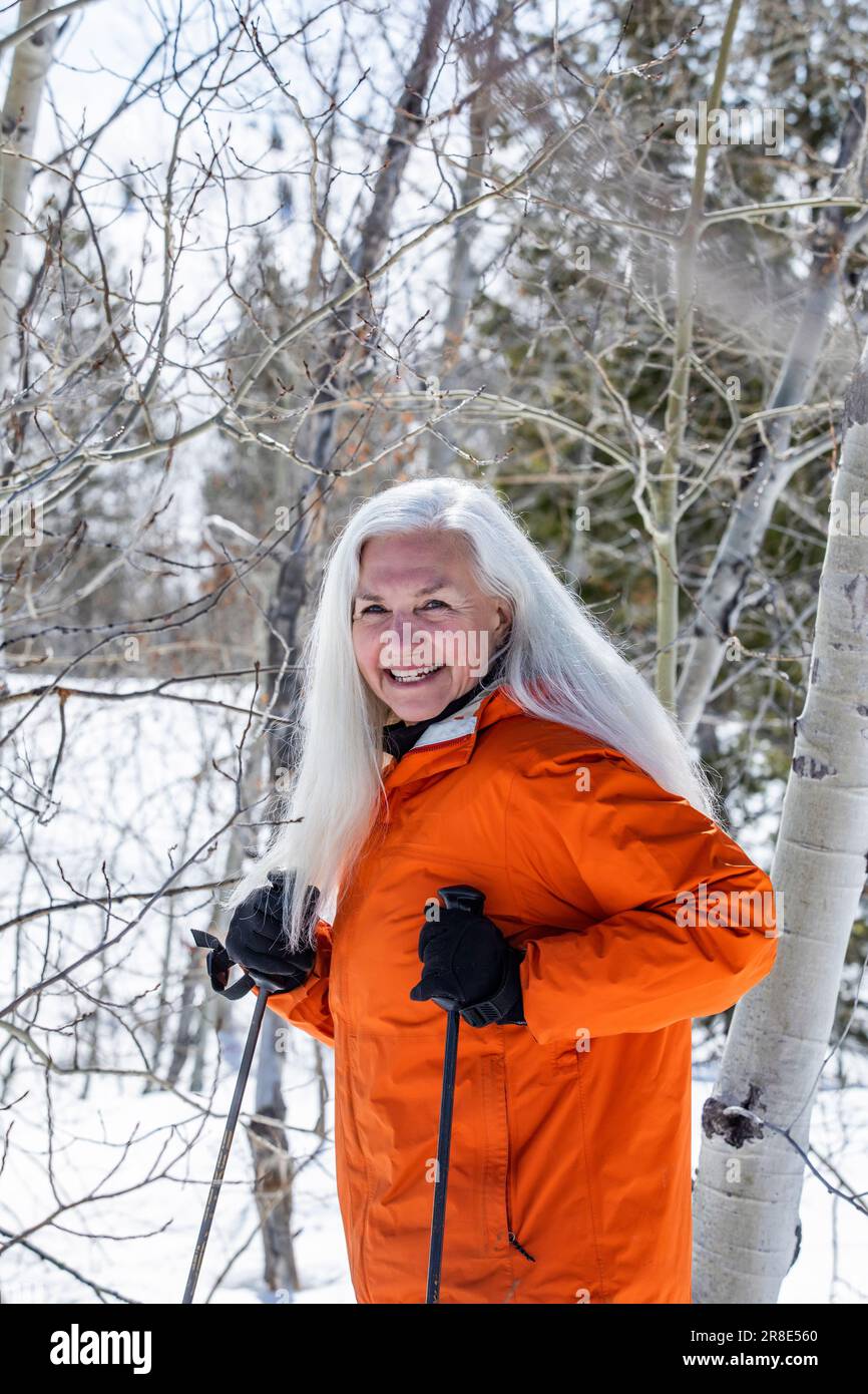 Lächelnde Frau beim Schneeschuhwandern im Winter Stockfoto