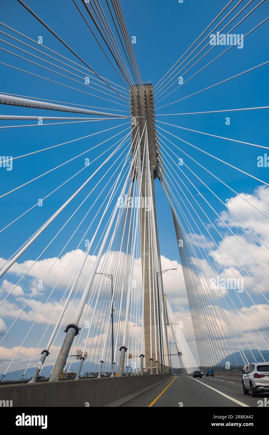 Moderner Brückenpylon vor blauem Himmel. Detail der mehrspaltigen Kabelbrücke. Lineare perspektivische Ansicht einer weissen Kabelaufhängung Alex Stockfoto