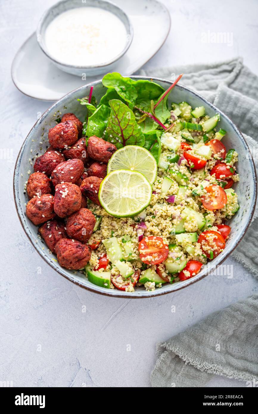 Buddha-Schüssel mit Rote-Bete-Falafel-Kugeln und Zitronenjoghurt-Dip. Tabbouleh-Salat. Levantinvegetarischer Salat. Stockfoto