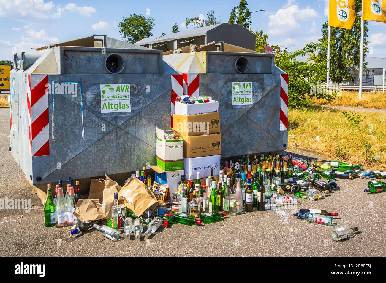 Hockenheim, Deutschland - 18. Juni 2023: Überfüllte Glasbehälter auf einer Straße. Recycling-Konzept und Müllentsorgung. Übersetzung: Kommerzieller Dienst, Stockfoto