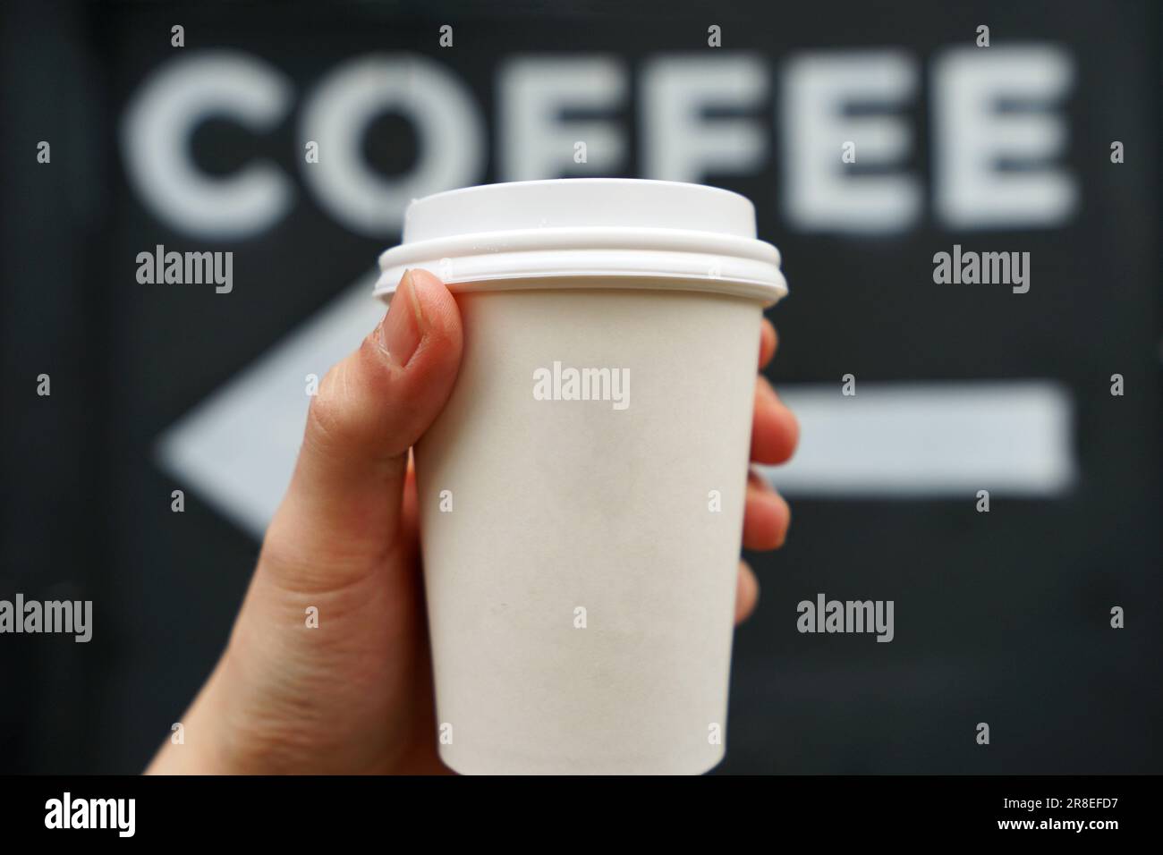 Nahaufnahme der Hand mit heißem Kaffee in einer Tasse zum Mitnehmen Stockfoto