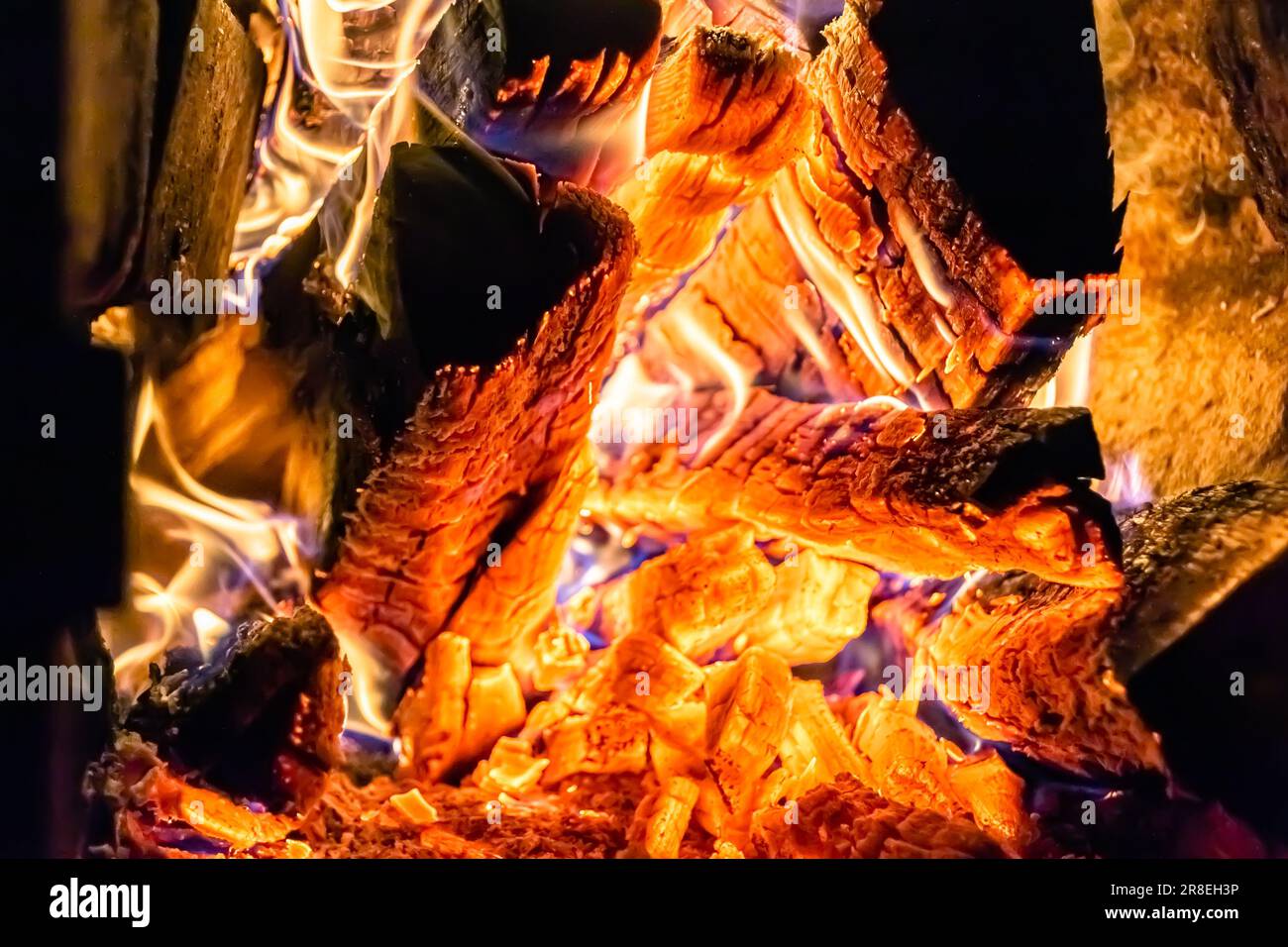 Schöner alter Kamin mit leichter Flamme Feuer für die Heizung des Bauraums, alter Kamin, bestehend aus dicken Eichenholzstämmen in heißer Flamme Feuer, hell f Stockfoto