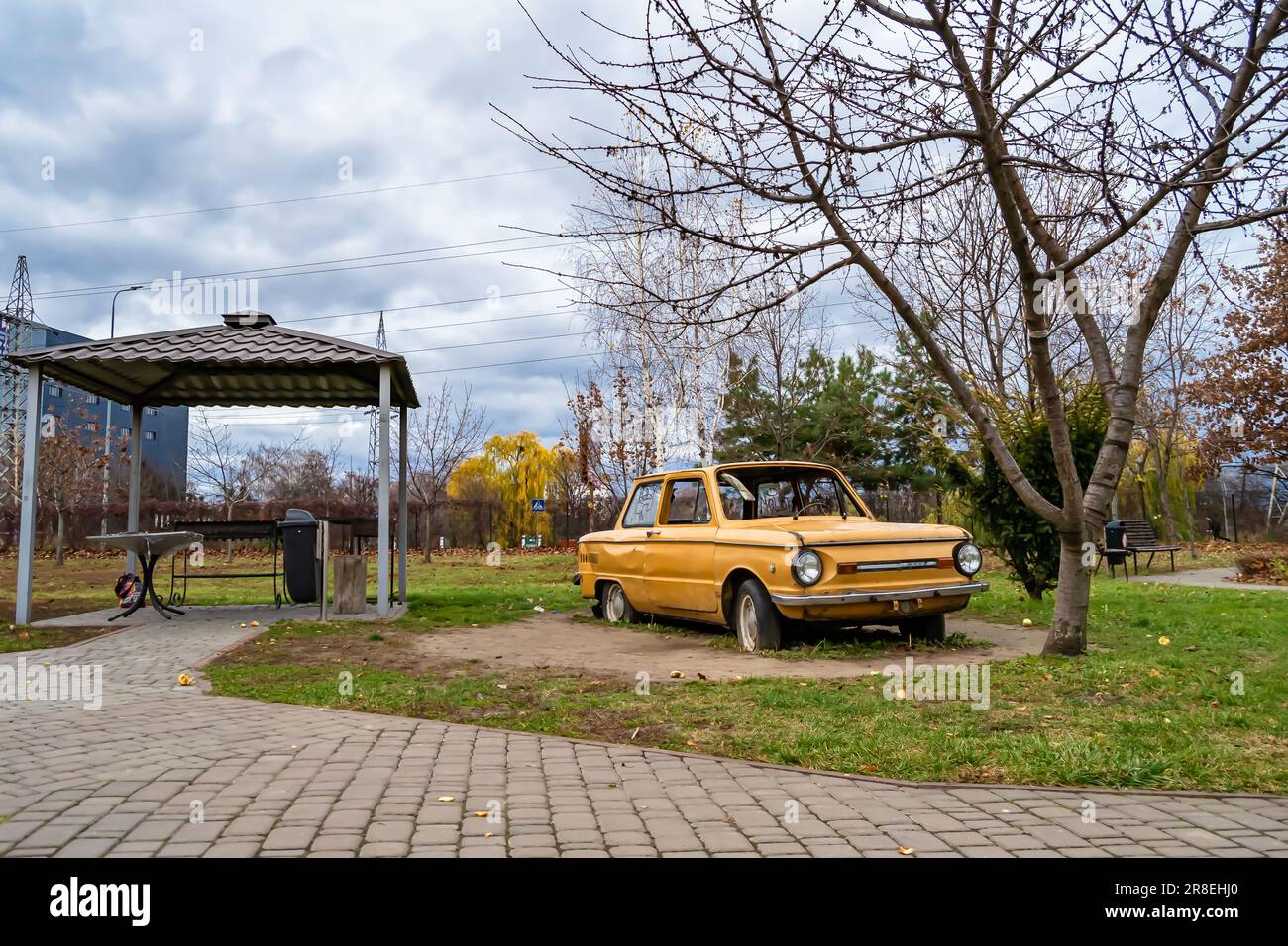 Fotografie zum Thema Super-altes Retro-Auto Zaporozhets steht im Park mit Platten Reifen, Foto bestehend aus einem sehr alten Retro-Auto mit zerbrochenem Glas nach einem Stockfoto