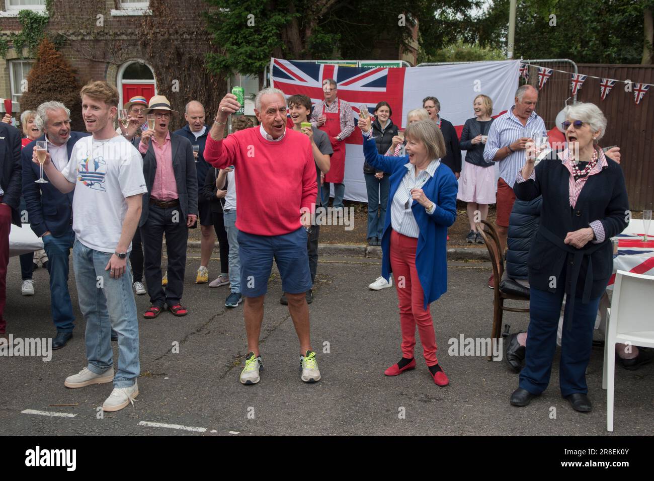 Treuer Toast Gott rette die Königin. Three Cheers Hip Hooray. Winchester, Hampshire, England, 5. Juni 2022. Queen Elizabeth II. Platinum Jubilee Straßenfest in der Grafton Road. Die Straße war geschlossen, mit Fähnchen dekoriert. Die Anwohner wurden ermutigt, rot, weiß und blau zu tragen. Um 12 Uhr gab es einen lokalen Toast und drei Anfeuerungen für die Königin und dann das Singen der Nationalhymne. HOMER SYKES AUS DEN 2020ER JAHREN Stockfoto Treuer Toast Gott rette die Königin. Three Cheers Hip Hooray. Winchester, Hampshire, England, 5. Juni 2022. Queen Elizabeth II. Platinum Jubilee Straßenfest in der Grafton Road. Die Straße war geschlossen, mit Fähnchen dekoriert. Die Anwohner wurden ermutigt, rot, weiß und blau zu tragen. Um 12 Uhr gab es einen lokalen Toast und drei Anfeuerungen für die Königin und dann das Singen der Nationalhymne. HOMER SYKES AUS DEN 2020ER JAHREN Stockfoto
