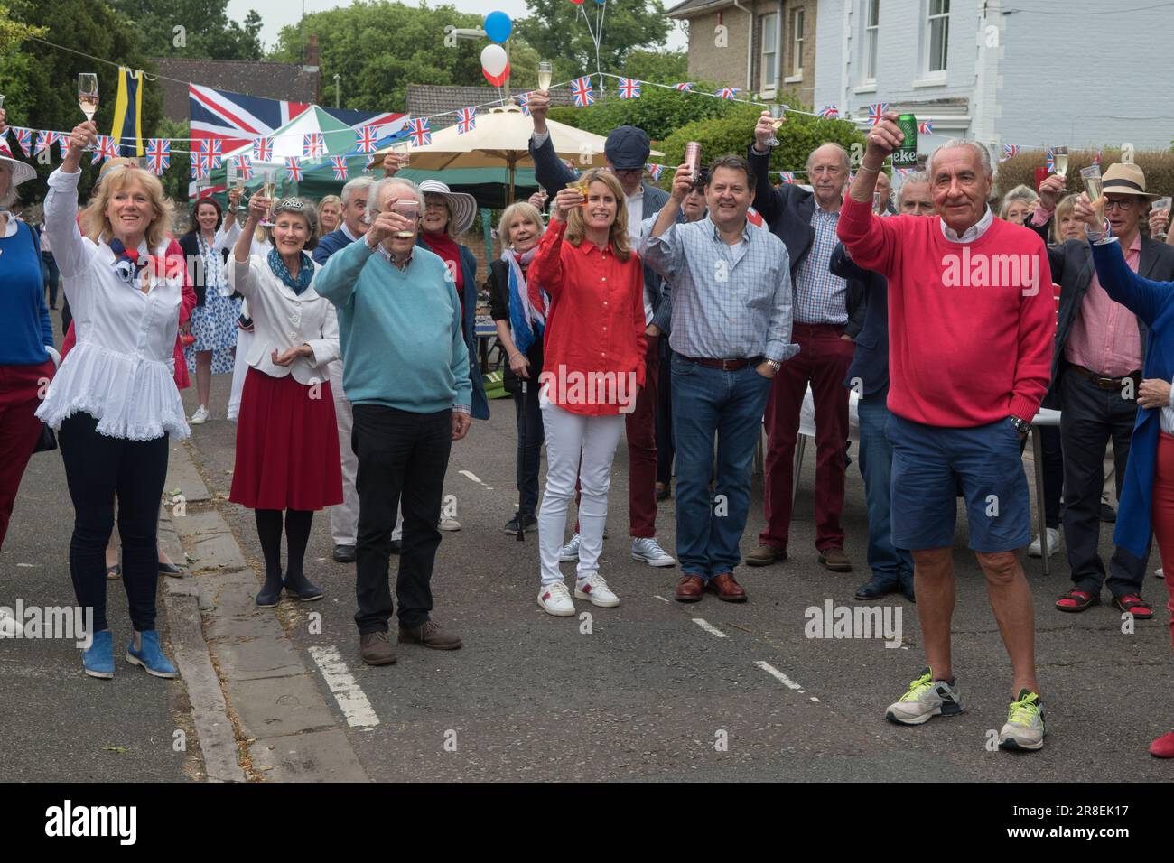 Treuer Toast Gott rette die Königin. Winchester, Hampshire, England, 5. Juni 2022. Queen Elizabeth II. Platinum Jubilee Straßenfest in der Grafton Road. Die Straße war geschlossen, mit Fähnchen dekoriert. Die Anwohner wurden ermutigt, rot, weiß und blau zu tragen. Um 12 Uhr gab es einen lokalen Toast und drei Anfeuerungen für die Königin und dann das Singen der Nationalhymne. HOMER SYKES AUS DEN 2020ER JAHREN Stockfoto