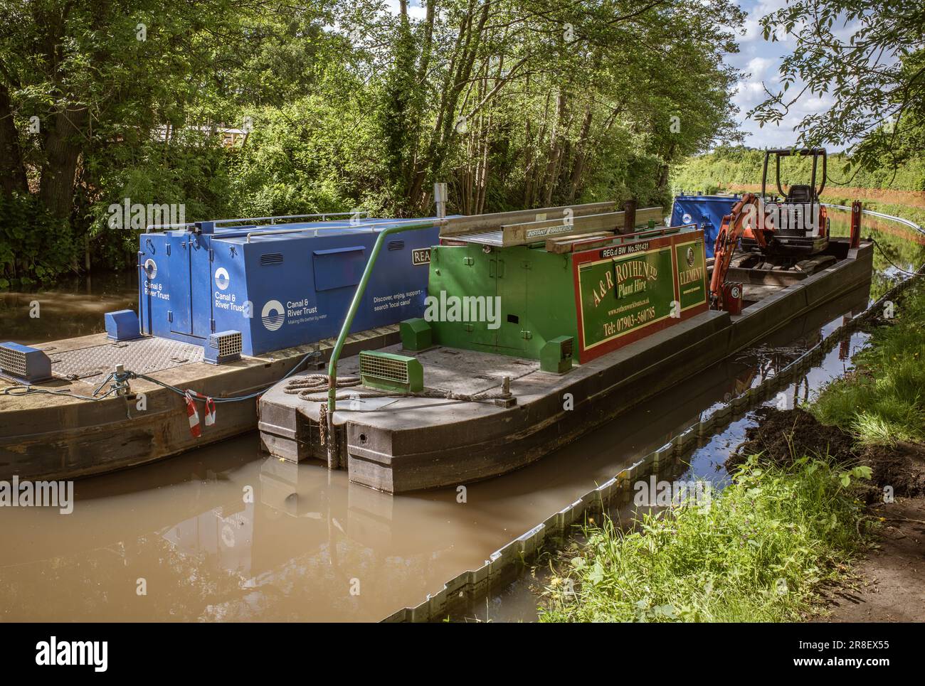Arbeitsboote auf einem Kanal in Worcestershire, von denen eines mit einem Bagger ausgestattet ist, bereiten sich darauf vor, wichtige Arbeiten entlang der Wasserstraße durchzuführen. Canal & River Trust. Stockfoto