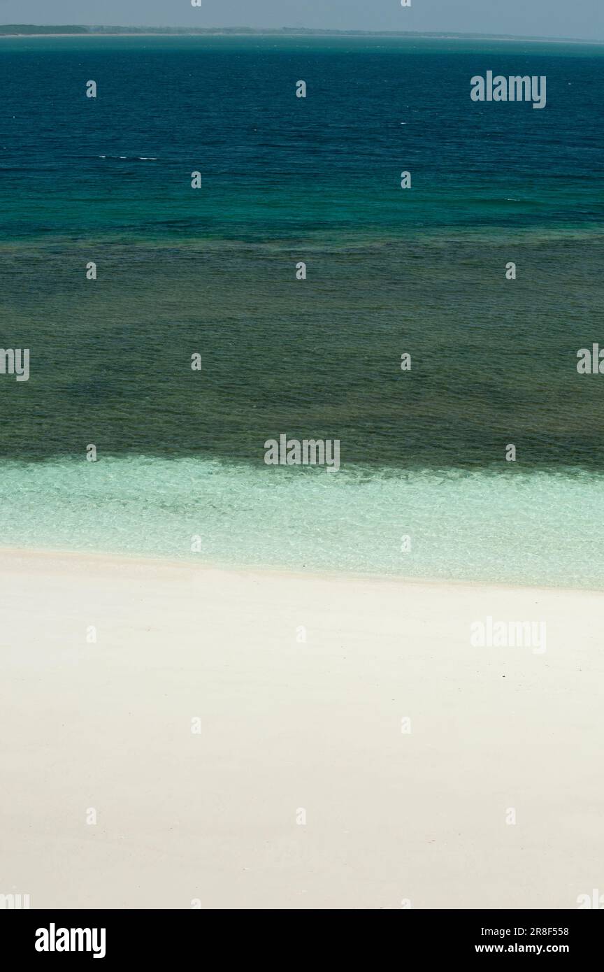 Christale Meereswellen brechen am weißen Sandstrand mit türkisfarbenem smaragdgrünen Wasser - Stockfoto Stockfoto