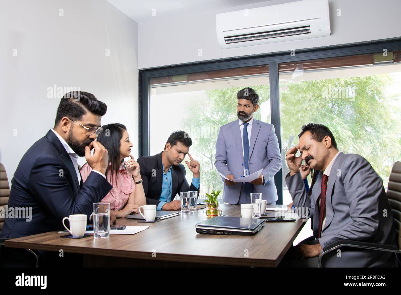 Stress-Situation im Konferenzraum, indischer Chef unzufrieden mit der Leistung seiner Mitarbeiter, weil sie schlechte Arbeit leisten. Stockfoto