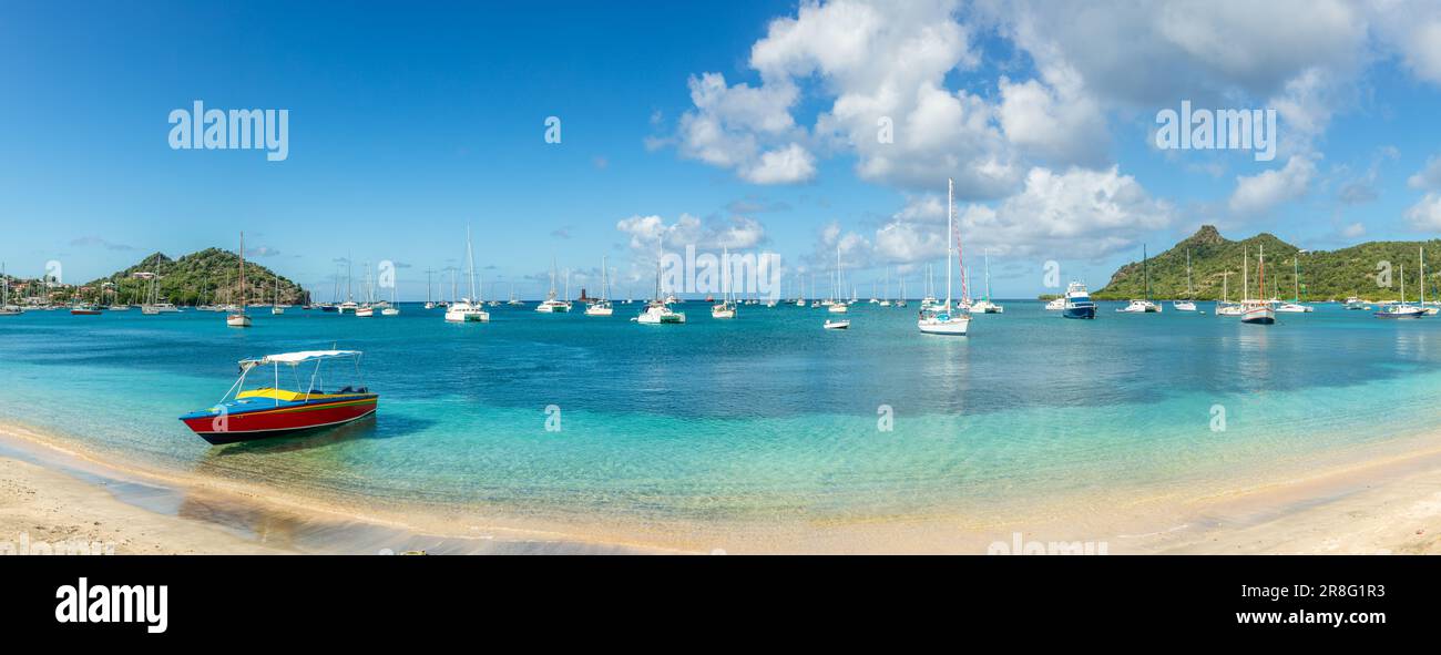 Türkisfarbenes Meer mit angehängten Yachten und Booten in der Lagune mit Sandstrand auf der Insel Carriacou, Grenada, Karibik Stockfoto