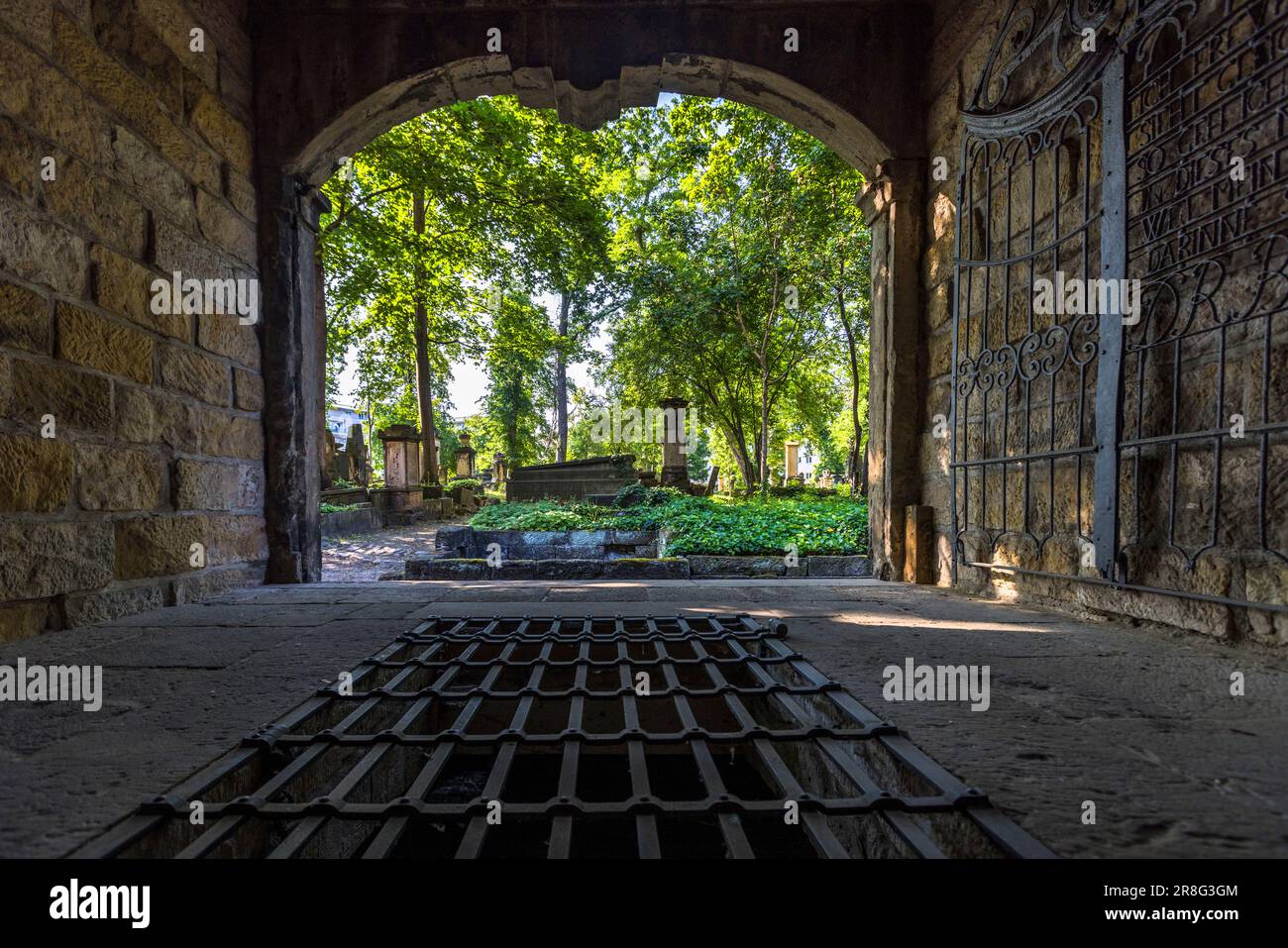 Blick aus einem Gruft-Haus auf dem Elias-Friedhof in Dresden. Unter dem Gitter befindet sich ein ummauerter Grabraum. Die Särge einer Familie wurden hier gestapelt. Diese Form der Bestattung verursachte jedoch, im Gegensatz zu irdenen Gräbern, eine große Geruchsbelästigung. Kryptengebäude mit bogenförmiger Front an der Friedhofswand sind eine Besonderheit des Elias-Friedhofs. Der Elias-Friedhof in Dresden ist seit 1876 stillgelegt und seit 1924 geschlossen Stockfoto