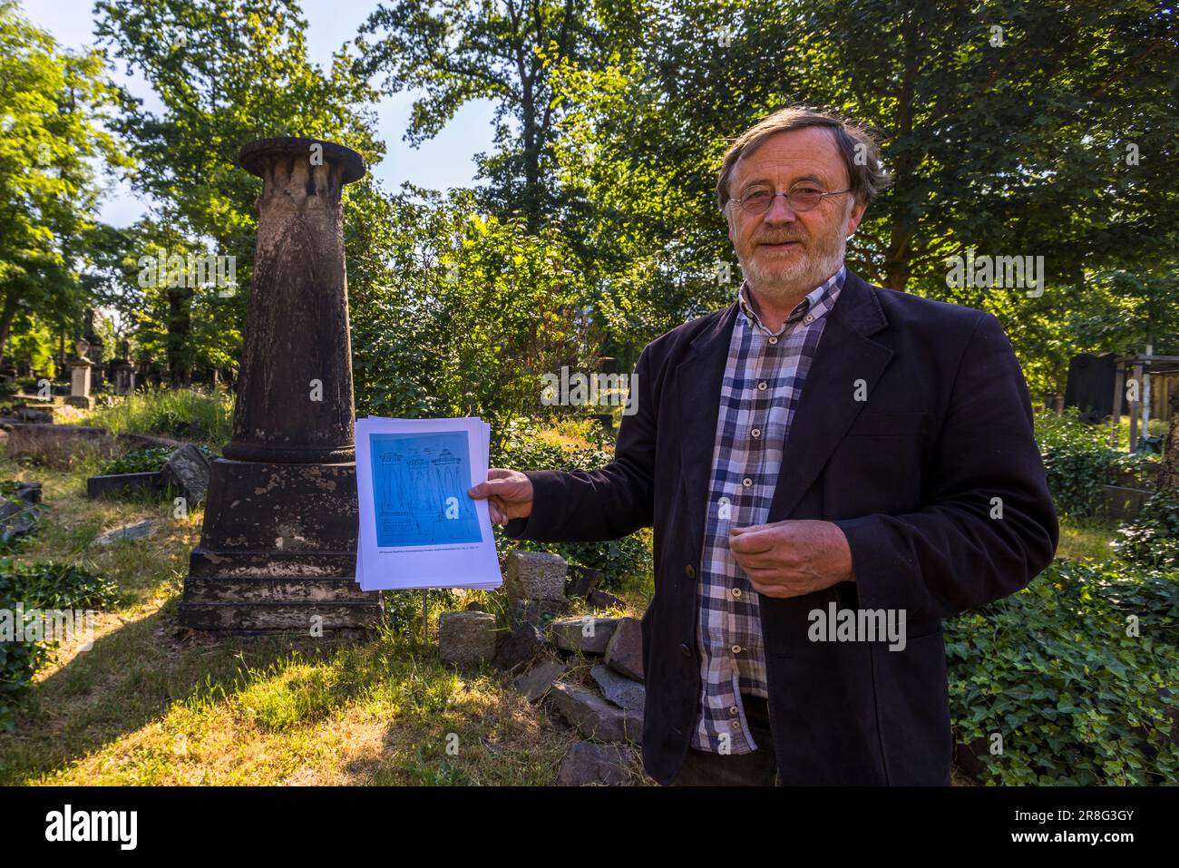 Volker Neumeister vom Elias-Friedhofsverein steht an einer Grabäule, die auf einem Entwurf von Caspar David Friedrich basiert, auf dem Elias-Friedhof in Dresden, Sachsen, Deutschland, und hält die Skizze des Malers in der Hand. Das Original wird im Kupferstichkabinett in Dresden aufbewahrt. Der Elias-Friedhof ist nicht für die Öffentlichkeit zugänglich, aber der Verein bietet regelmäßige Führungen an. Der 1680 als Pesthof angelegte Elias-Friedhof wurde 1724 unter den Baumeistern George Bähr, Architekt der Dresdner Frauenkirche, und Johann Gottfried Fehre, der 41 Gewölbe hinzufügte, erheblich erweitert und ummauert Stockfoto