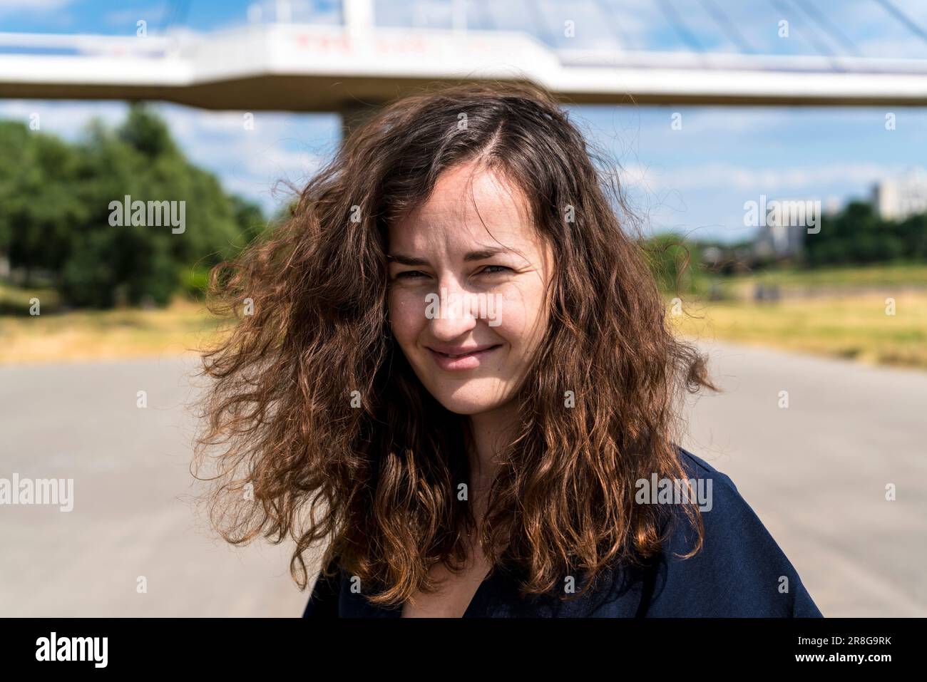 Junge Frau mit offenem Haar in urbaner Umgebung Stockfoto