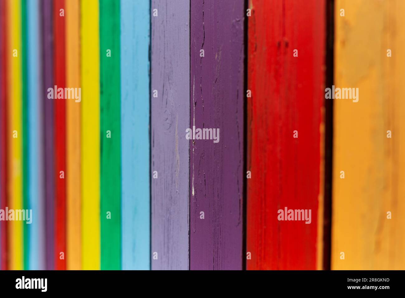 Ein alter Zaun malt leuchtende Farben für ein auffälliges Muster. Stockfoto