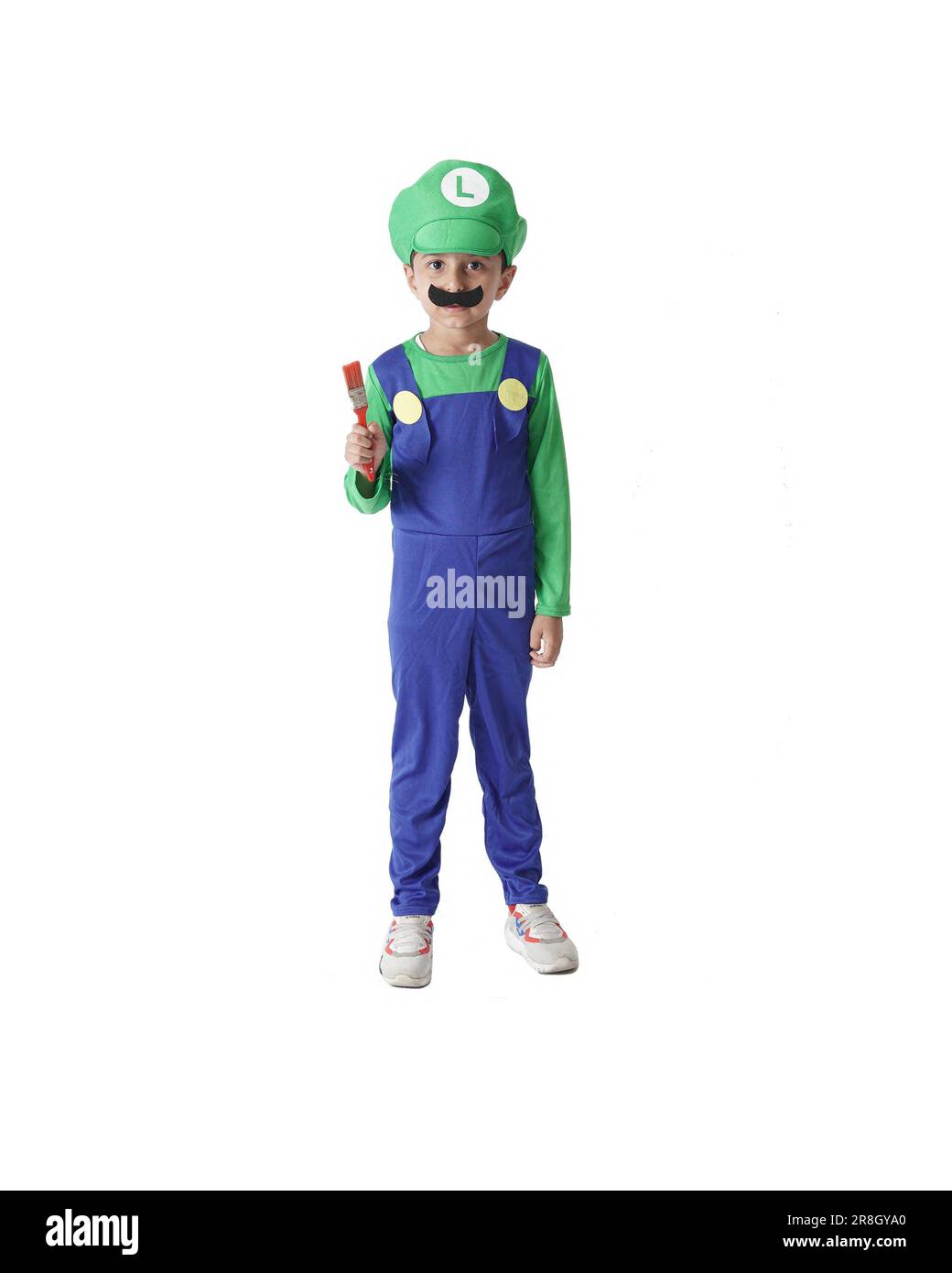 Super Mario Bros Kinderfoto, ein Kind trägt ein Luigi-Kostüm und hält einen Pinsel isoliert auf weißem Hintergrund. Stockfoto