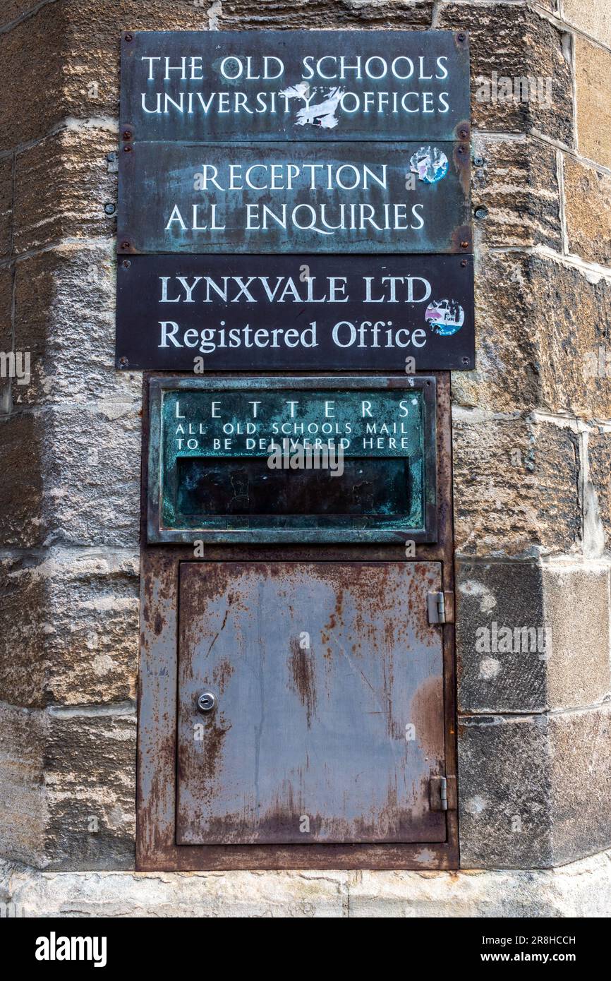 Die Plaketten für die Büros der Old Schools University und LynxVale über einem Briefkasten an einer abgenutzten Steinmauer auf der Trinity Lane, University of Cambridge, Großbritannien Stockfoto