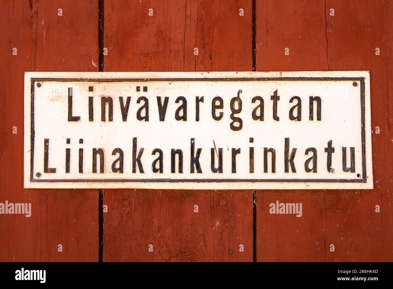 Altes Straßenschild von Linvävaregatan (Liinakankurinkatu) an der roten Ocker-Holzwand in Barckens Udde, der Altstadt von Ekenäs (Tammisaari), Finnland Stockfoto