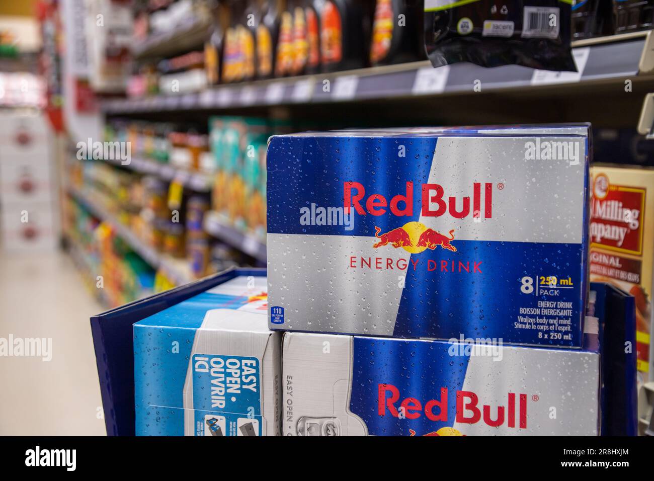 8 Dosen Red Bull werden im Lebensmittelgeschäft ausgestellt. Red Bull ist eine beliebte Energy-Drink-Marke des österreichischen Unternehmens Red Bull GmbH. Stockfoto