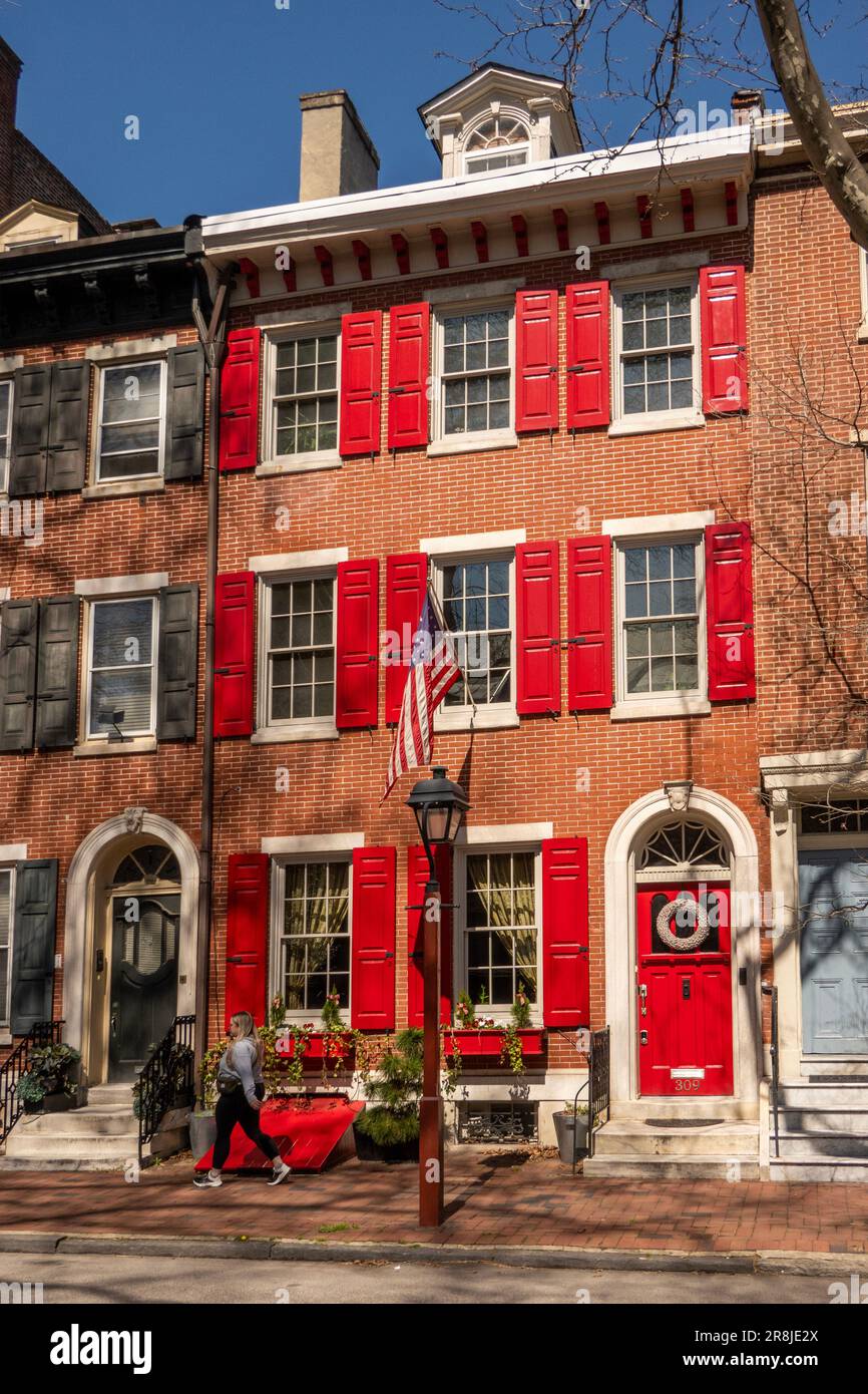 Haus aus Kolonialziegel mit roter Tür und Fensterläden in Philadelphia PA Stockfoto