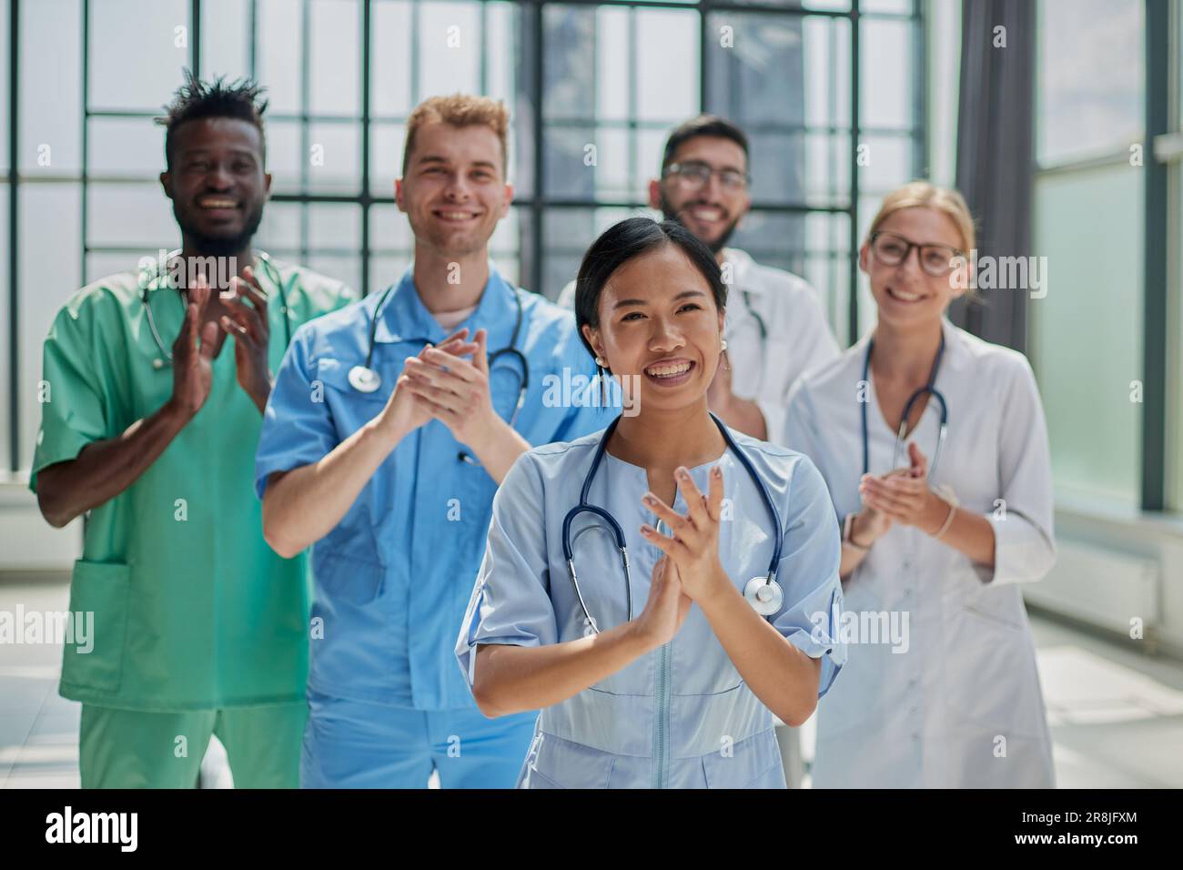 Professionelle multinationale Ärzte applaudieren vor der Kamera. Diagnosediskussion Stockfoto