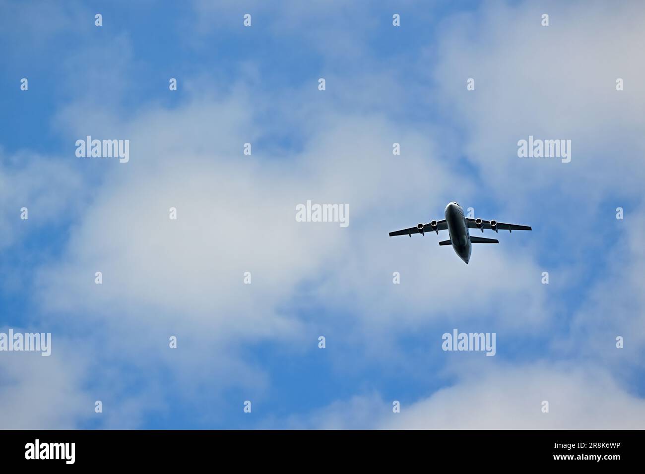 Ein Pendler-Passagierflugzeug, das in einem wolkengefüllten Himmel fliegt Stockfoto
