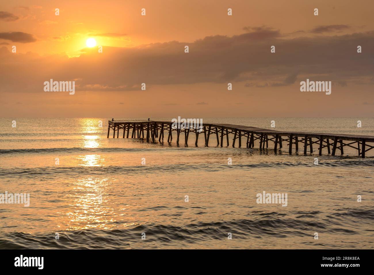 Sommersonnenaufgang auf einem hölzernen Pier an einem Strand in Platja de Muro (Mallorca, Balearen, Spanien) ESP: Amanecer veraniego en un muelle de madera en Muro Stockfoto