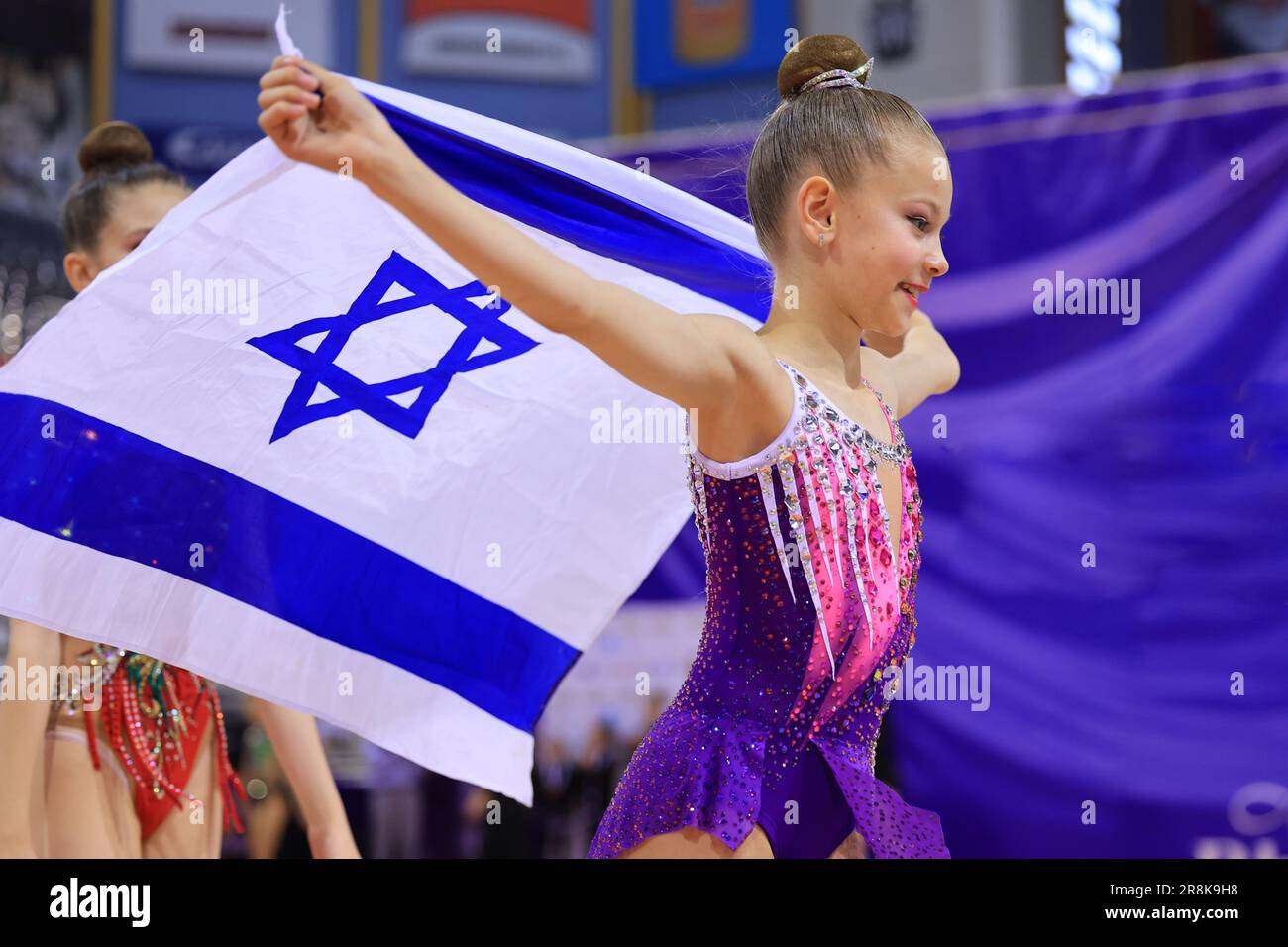 Ein patriotisches jüdisches Mädchen, das mit der Flagge Israels steht und es genießt. Patriotischer Feiertag Unabhängigkeitstag Israel - Konzept Jom Ha'atzmaut. Stockfoto