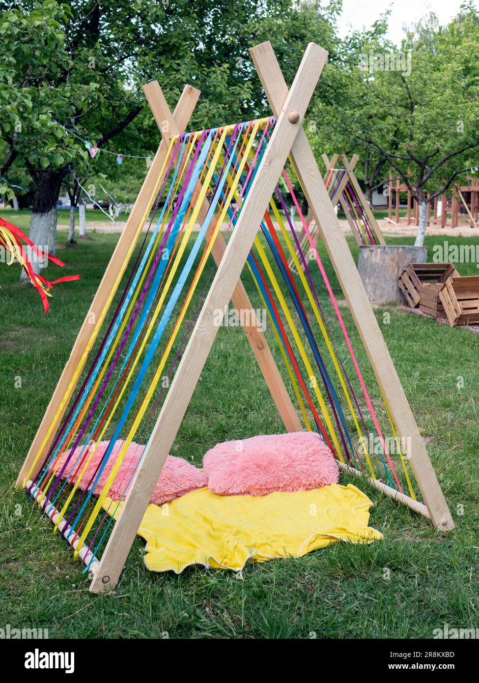 Ruhe- oder Spielzelte aus bunten Bändern mit Kissen und Decke im Freien, selektiver Fokus. Idealer Ort zum Entspannen für Kinder und Erwachsene Stockfoto